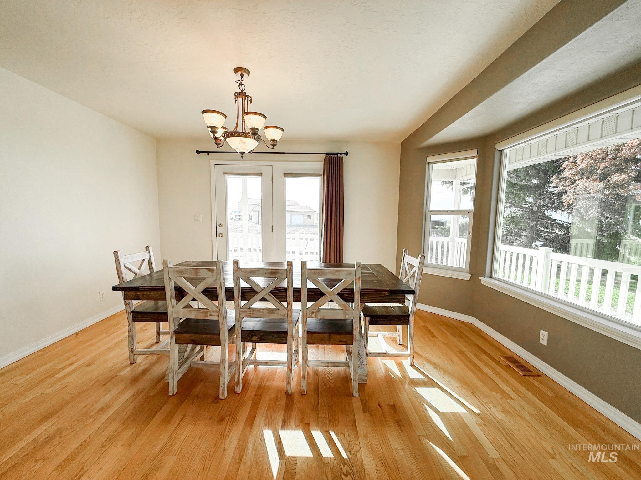 Dining space featuring light wood finished floors and a chandelier