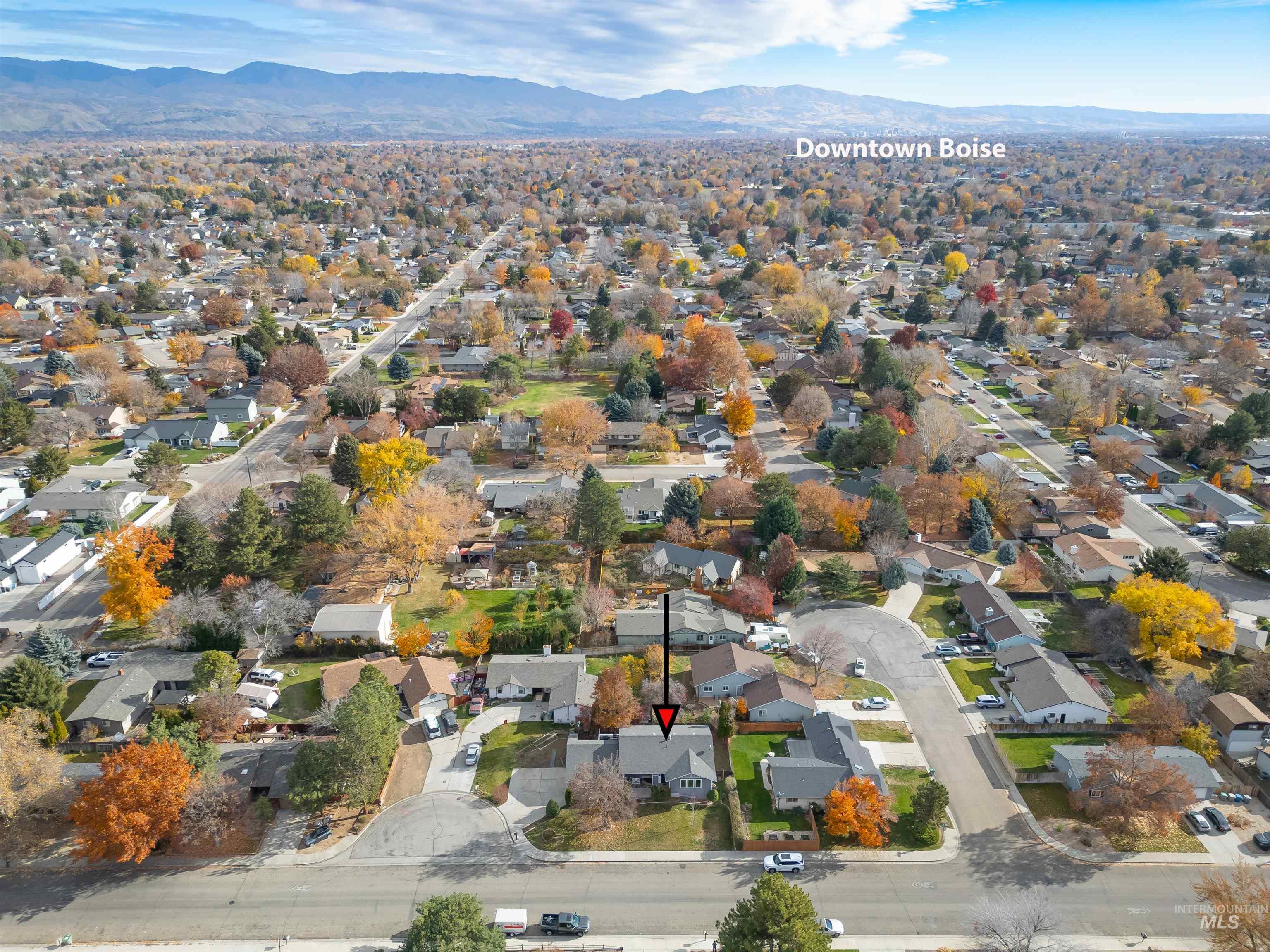 Aerial view of property's location with a mountain backdrop and nearby suburban area