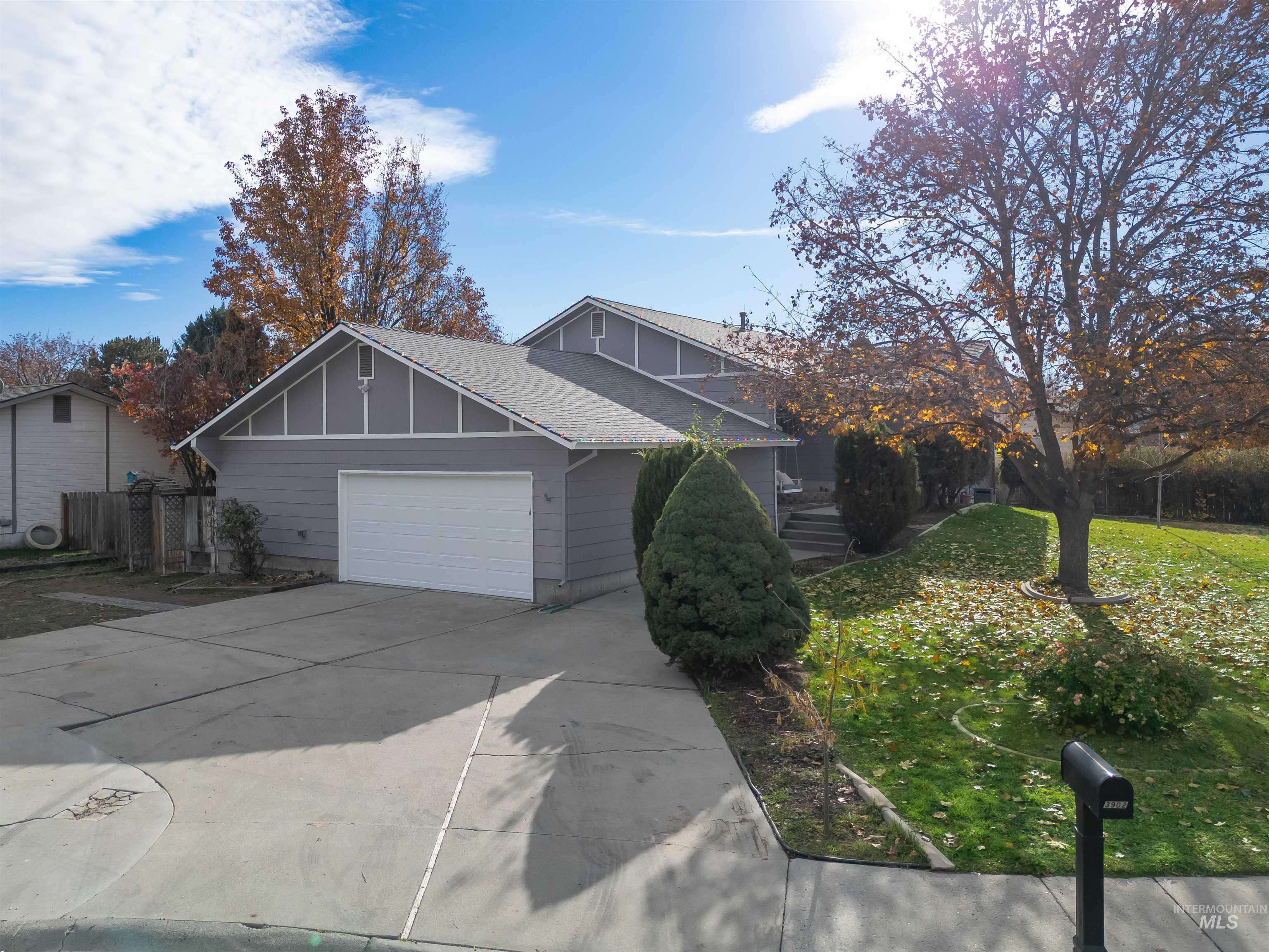 View of front of house featuring board and batten siding, driveway, a garage, and roof with shingles