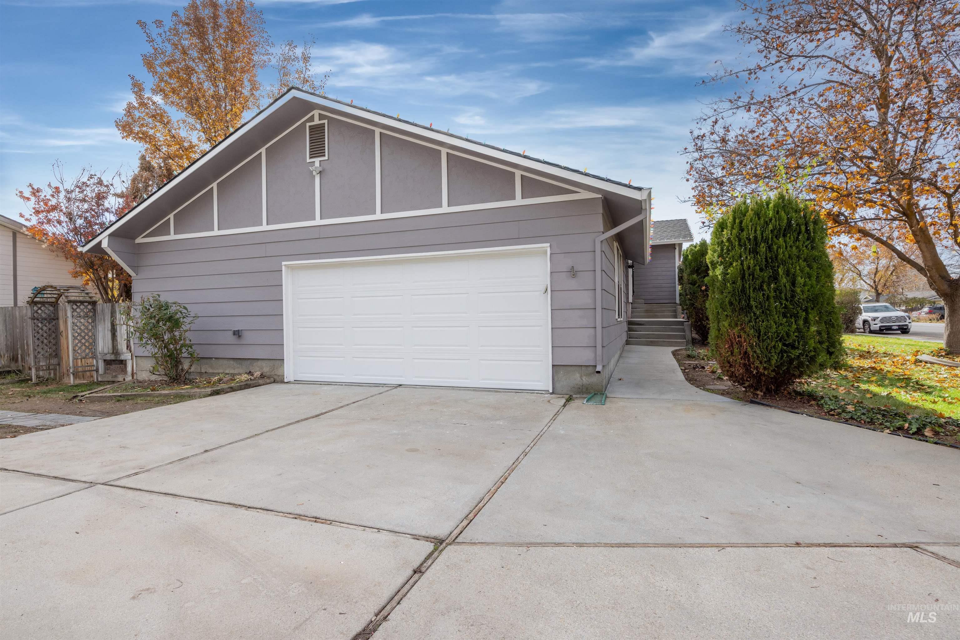 Ranch-style home featuring concrete driveway and board and batten siding