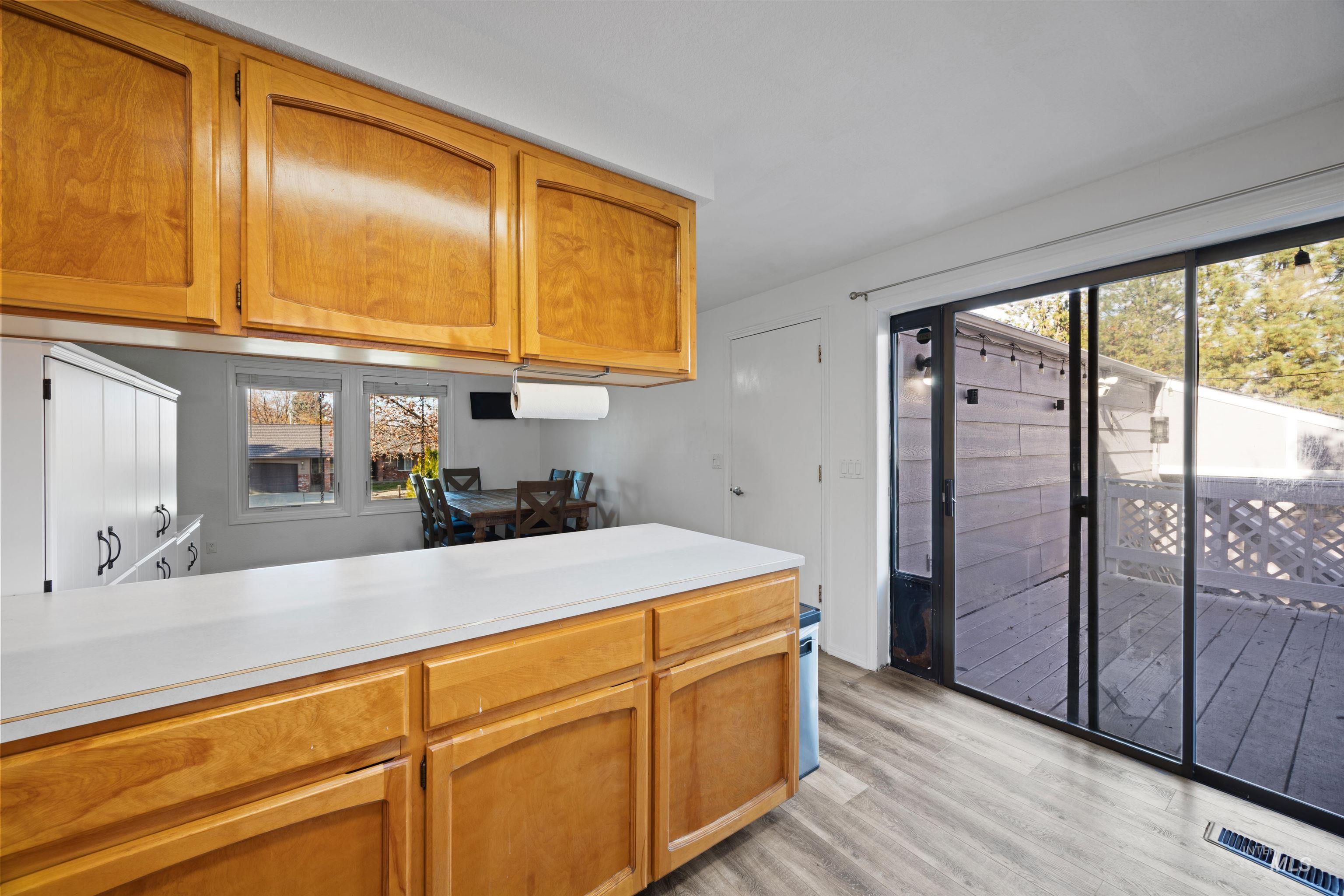 Kitchen with light countertops, brown cabinets, and light wood-type flooring