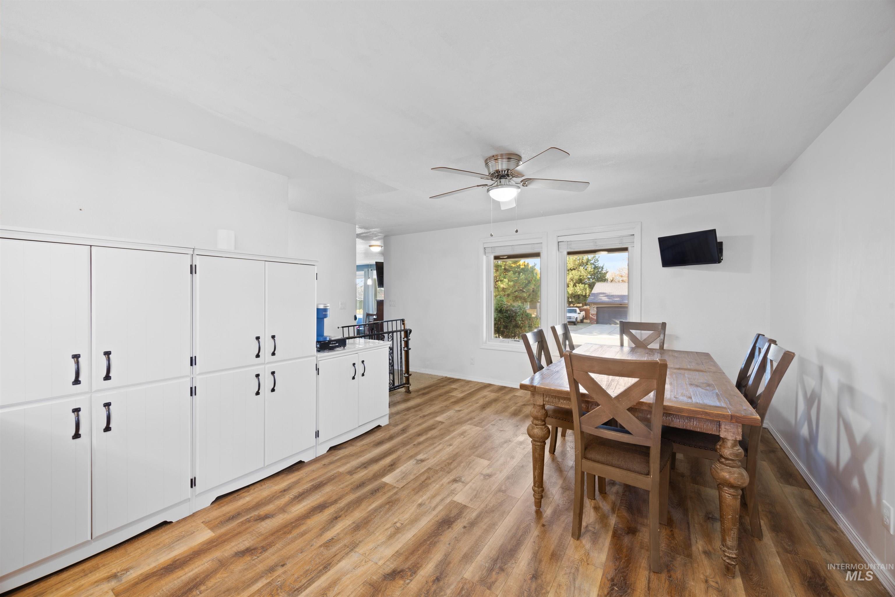 Dining space with light wood-style floors and ceiling fan