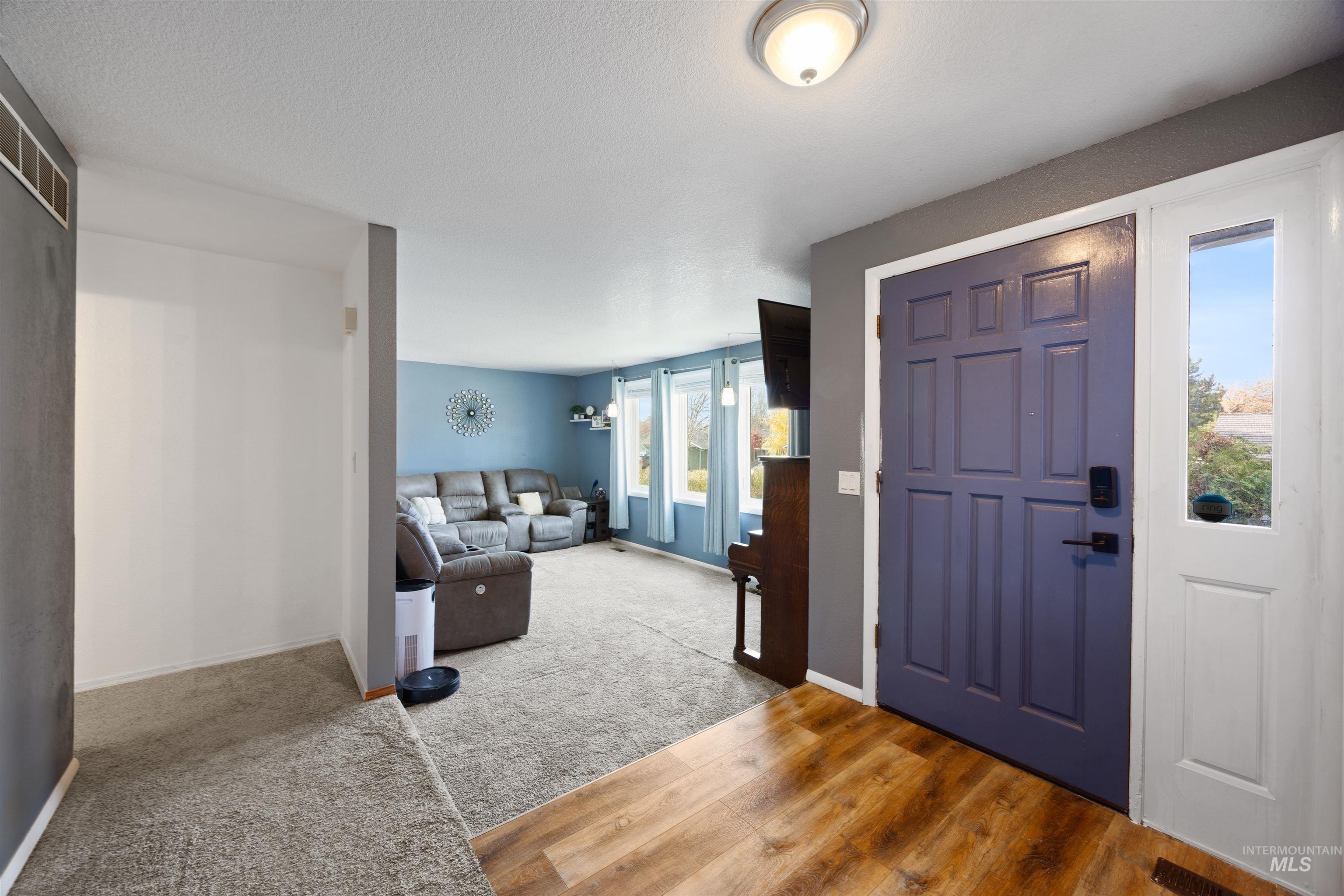 Entryway with light wood-type flooring and light carpet