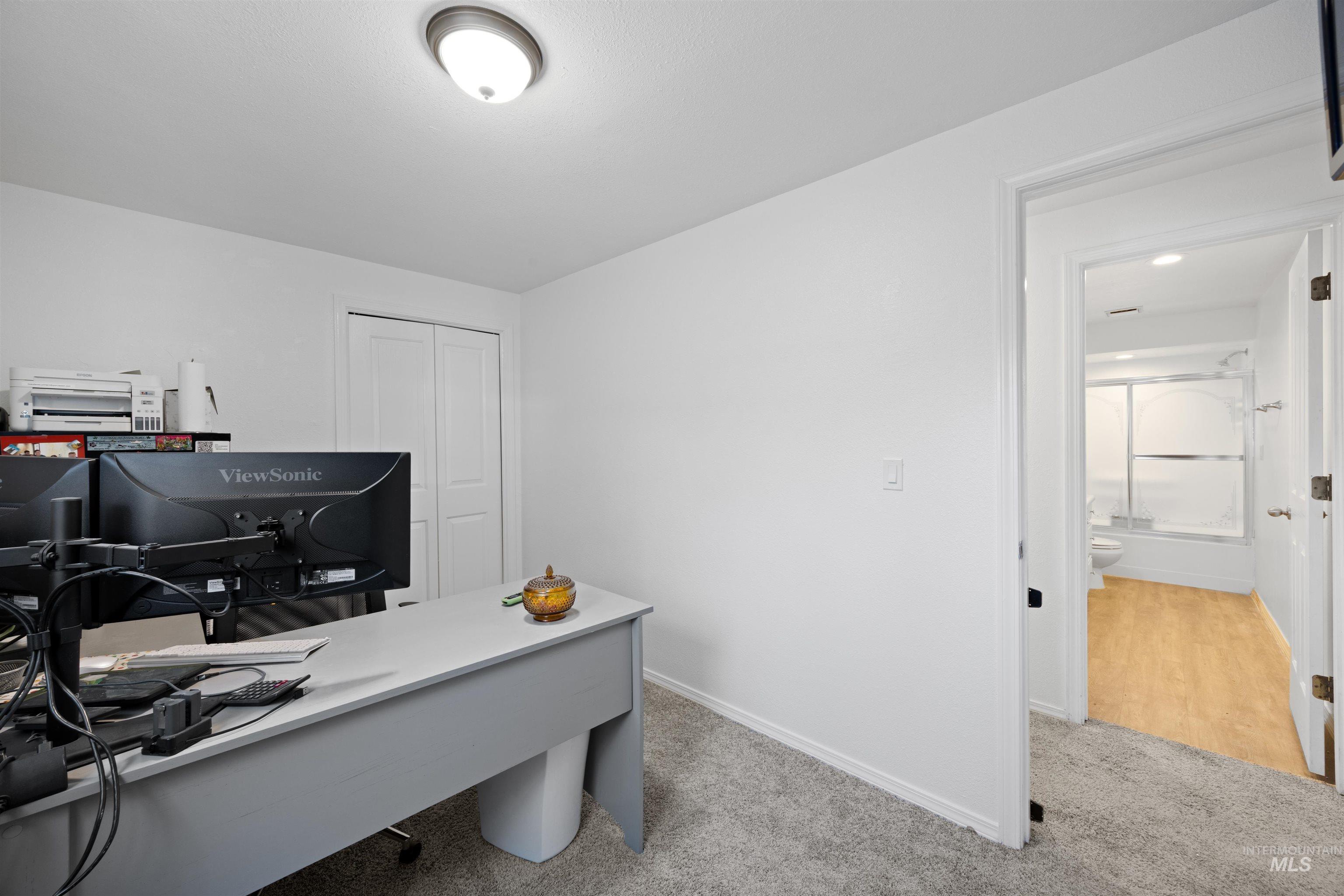 Office with light carpet and baseboards