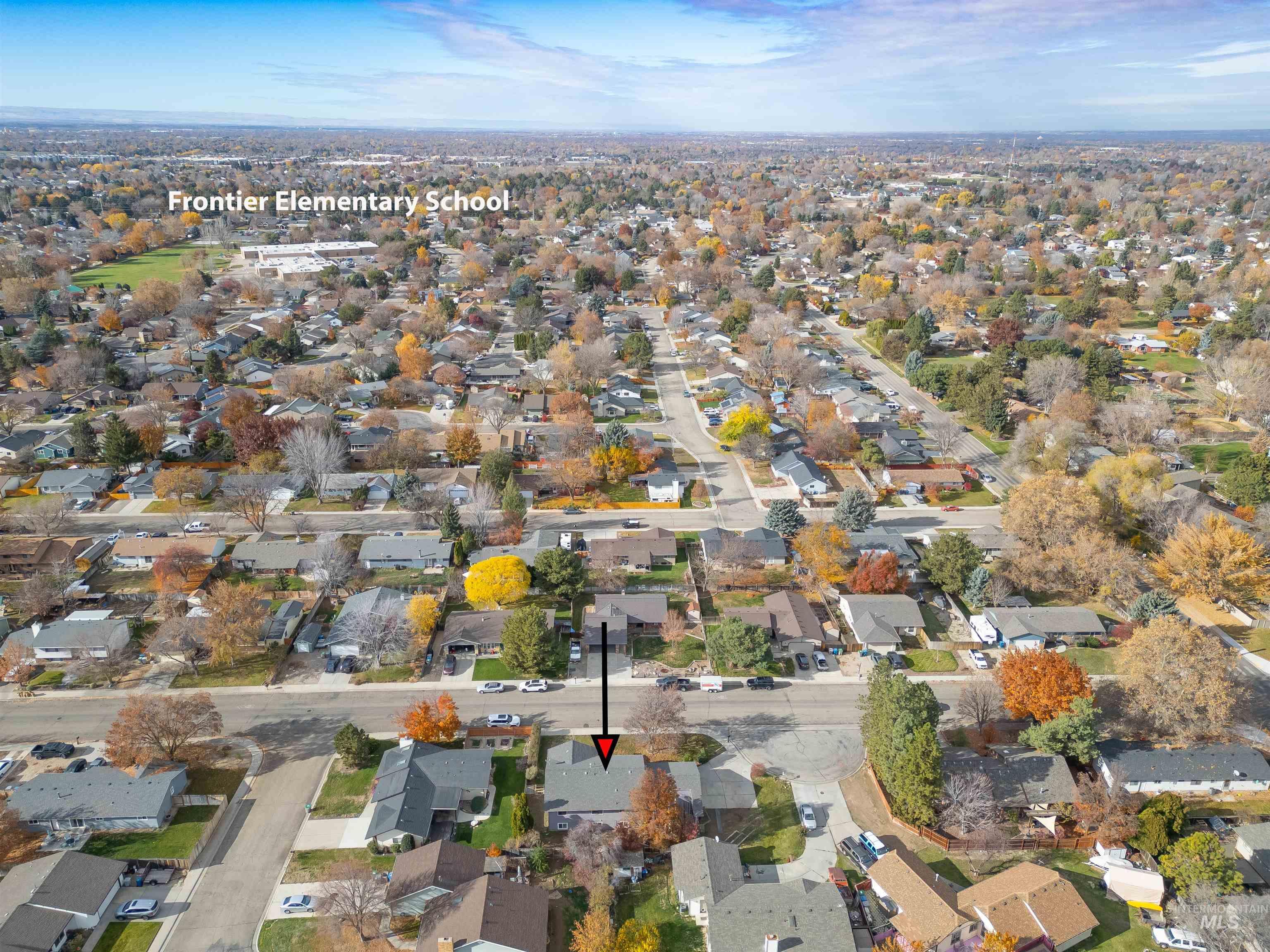 Aerial view of property and surrounding area with nearby suburban area