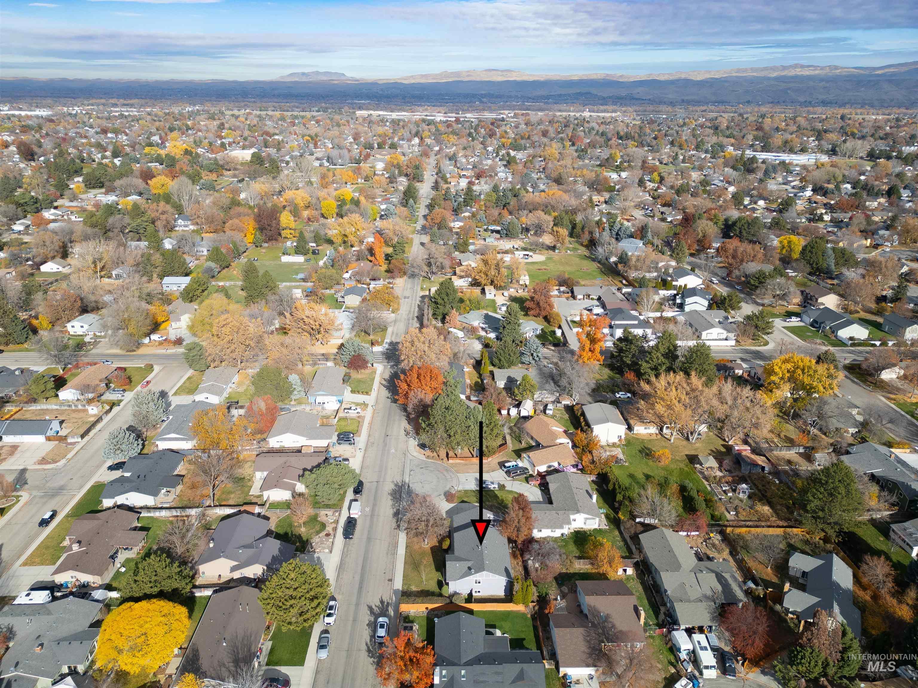 Aerial view of property's location featuring a mountain backdrop and nearby suburban area