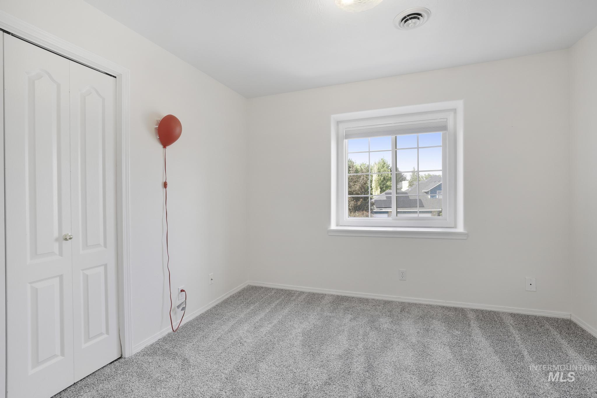 Unfurnished bedroom with light colored carpet and a closet