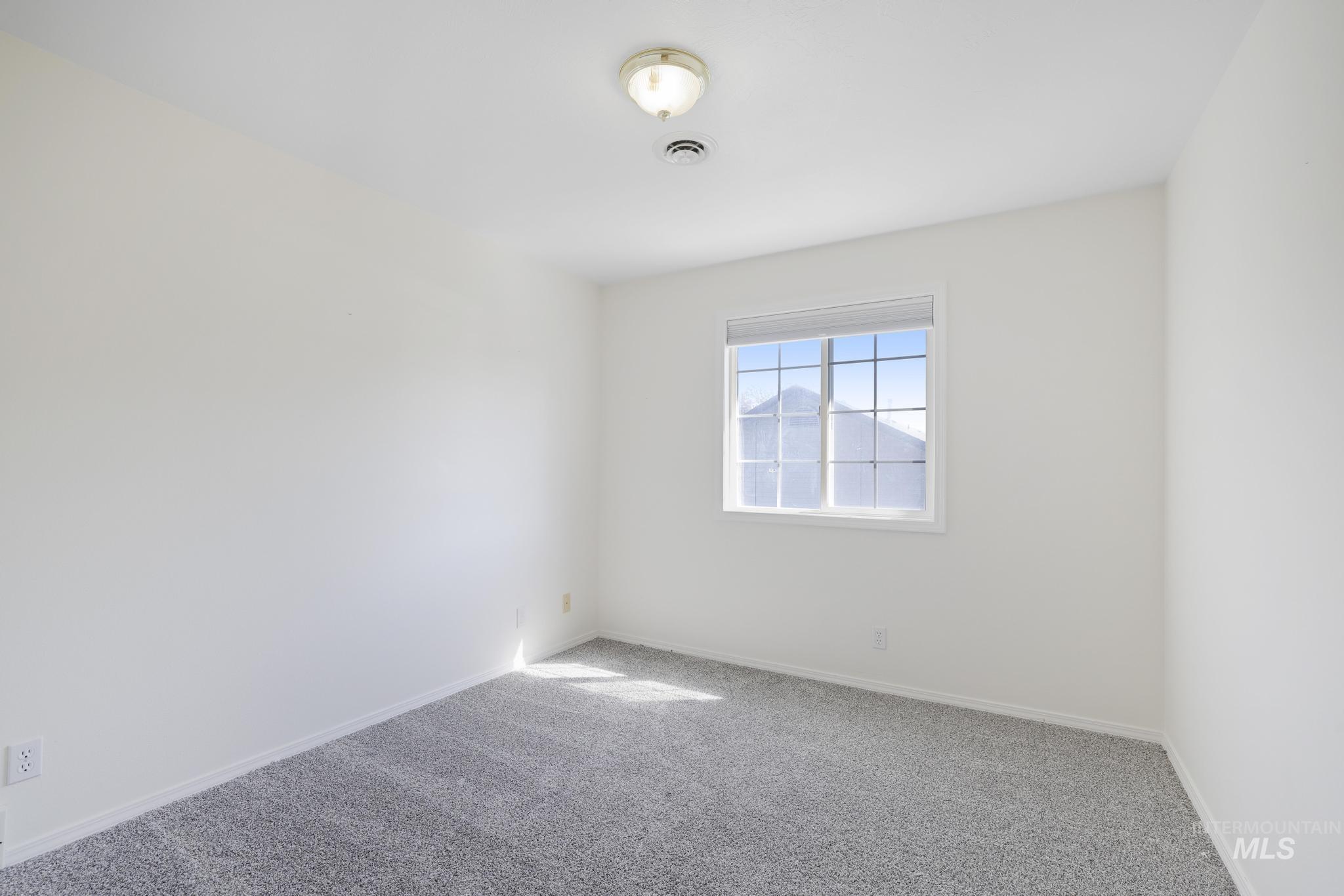 Carpeted empty room featuring baseboards
