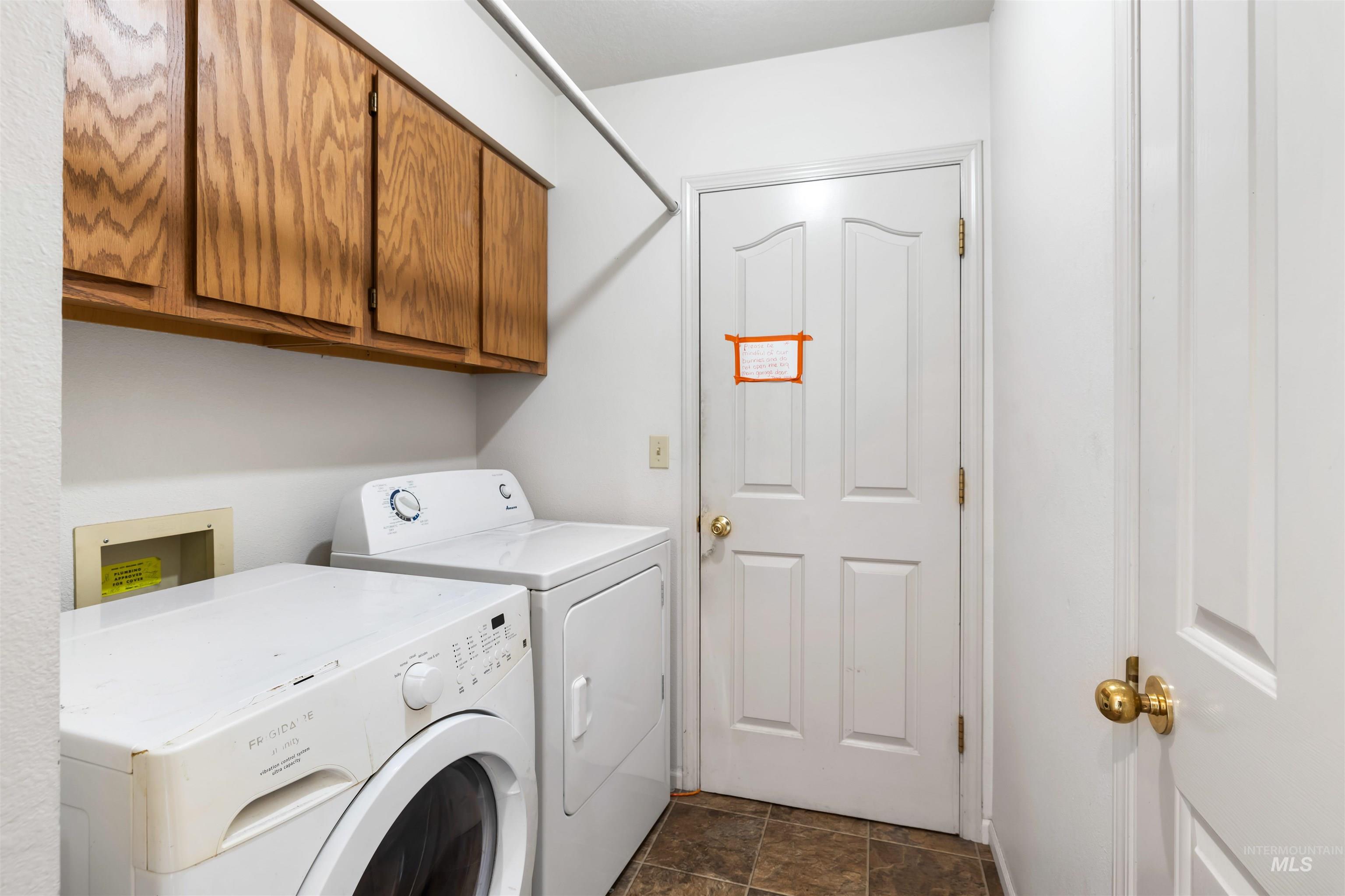 Washroom featuring separate washer and dryer and cabinet space