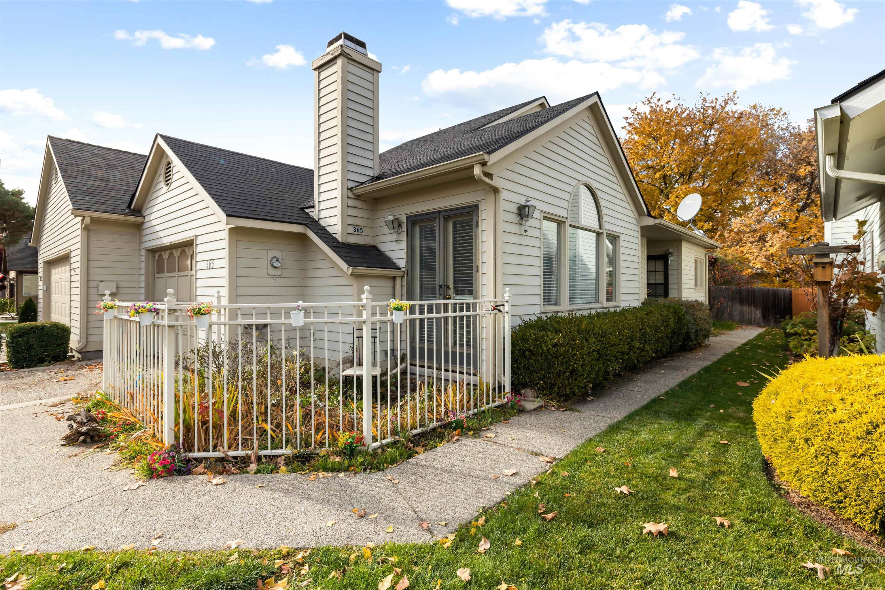 View of side of property with roof with shingles, a chimney, and an attached garage