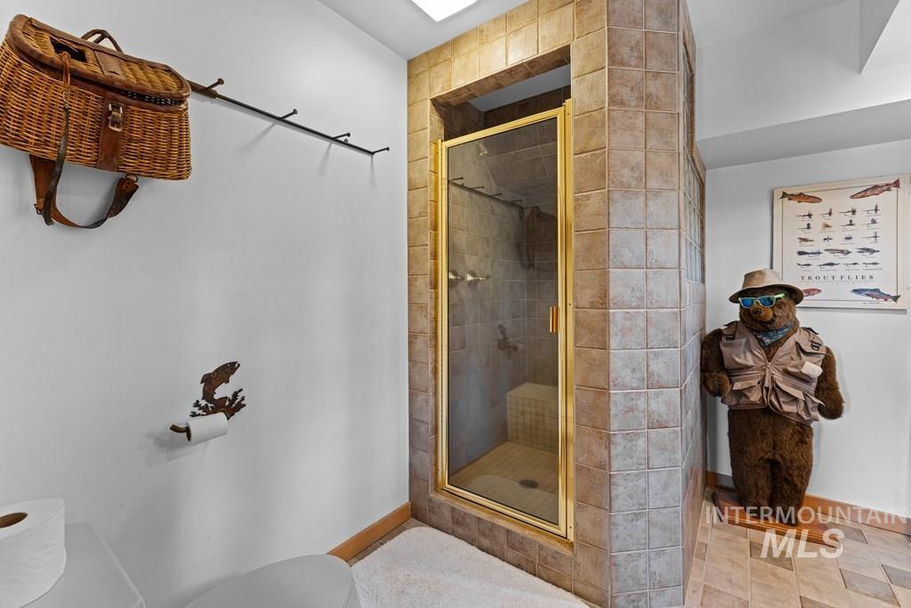 Tiled shower enclosure with a gold-tone framed glass door and integrated bench seating