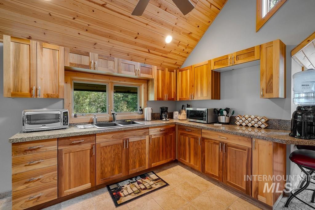 Kitchen featuring wood cabinetry, light-toned countertops, and a double-basin sink