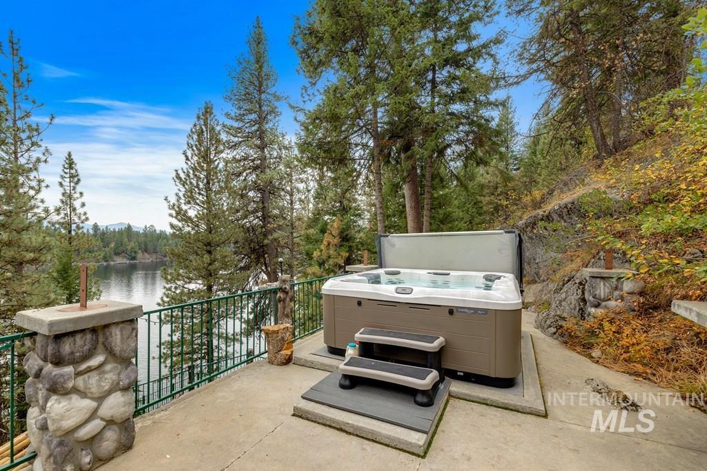 Outdoor hot tub situated on a concrete patio with a metal railing