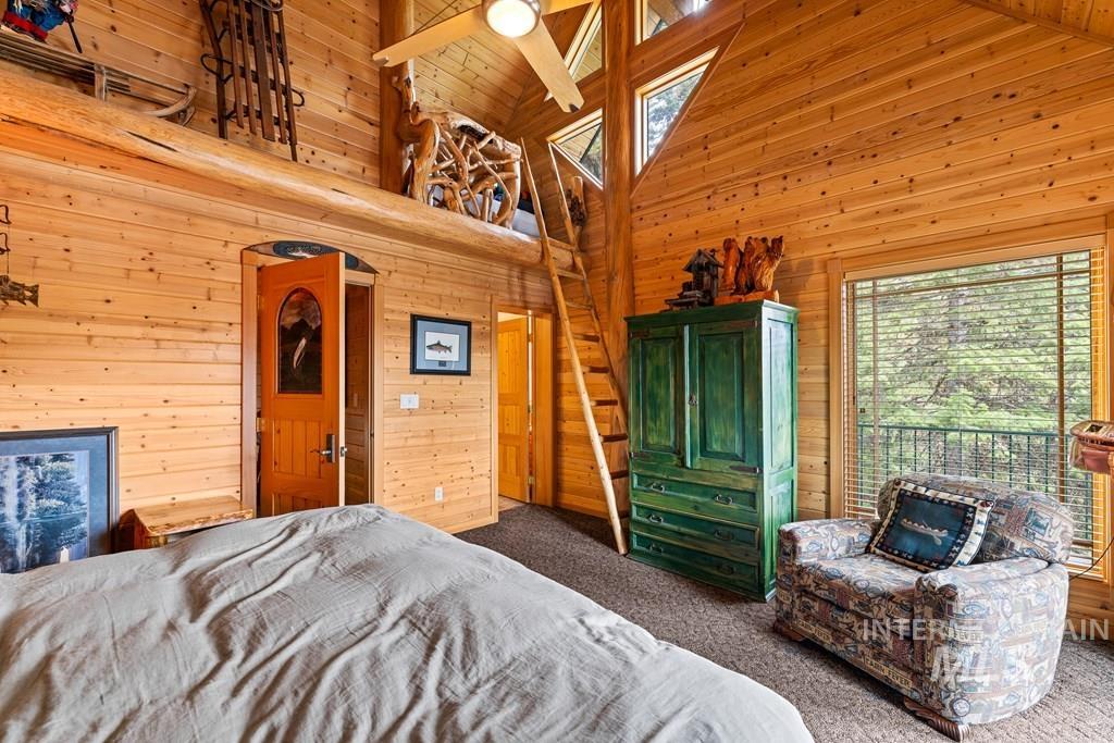 Wood-paneled room with a vaulted ceiling and exposed log beams