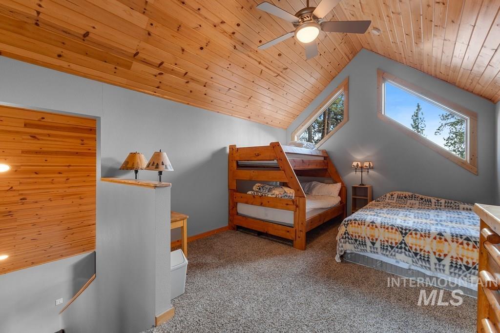 Vaulted wood-paneled ceiling with a central ceiling fan
