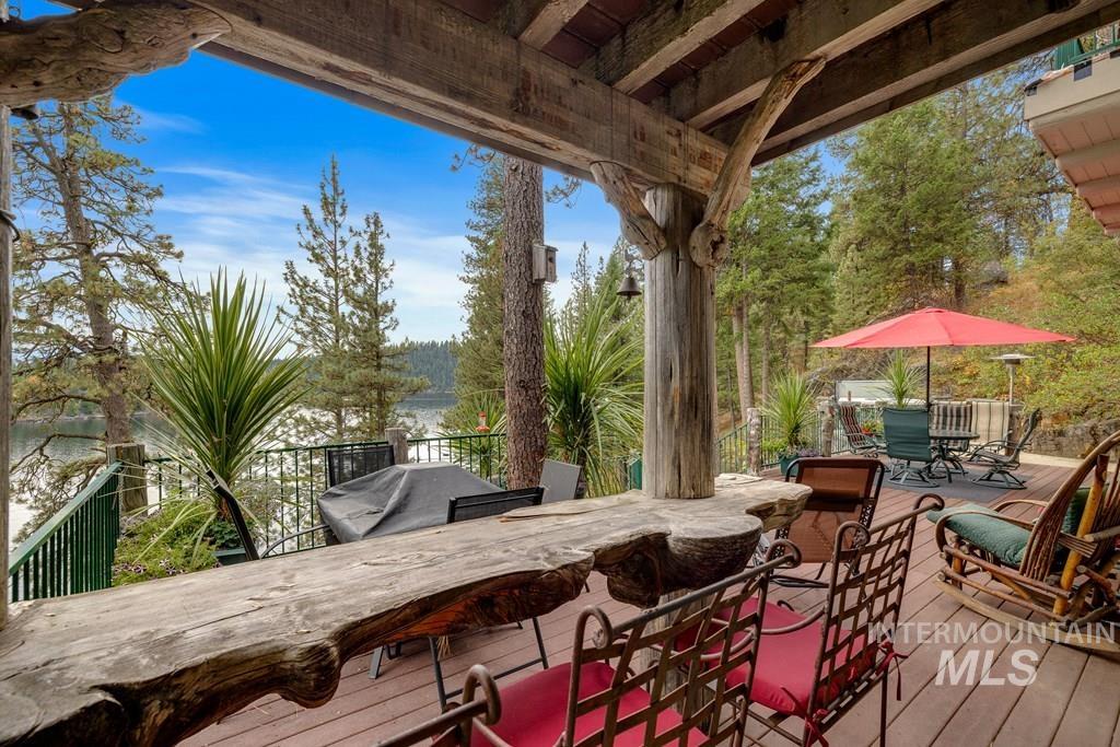 Expansive outdoor deck featuring a handcrafted live-edge wooden bar, natural wood support beams, and durable decking