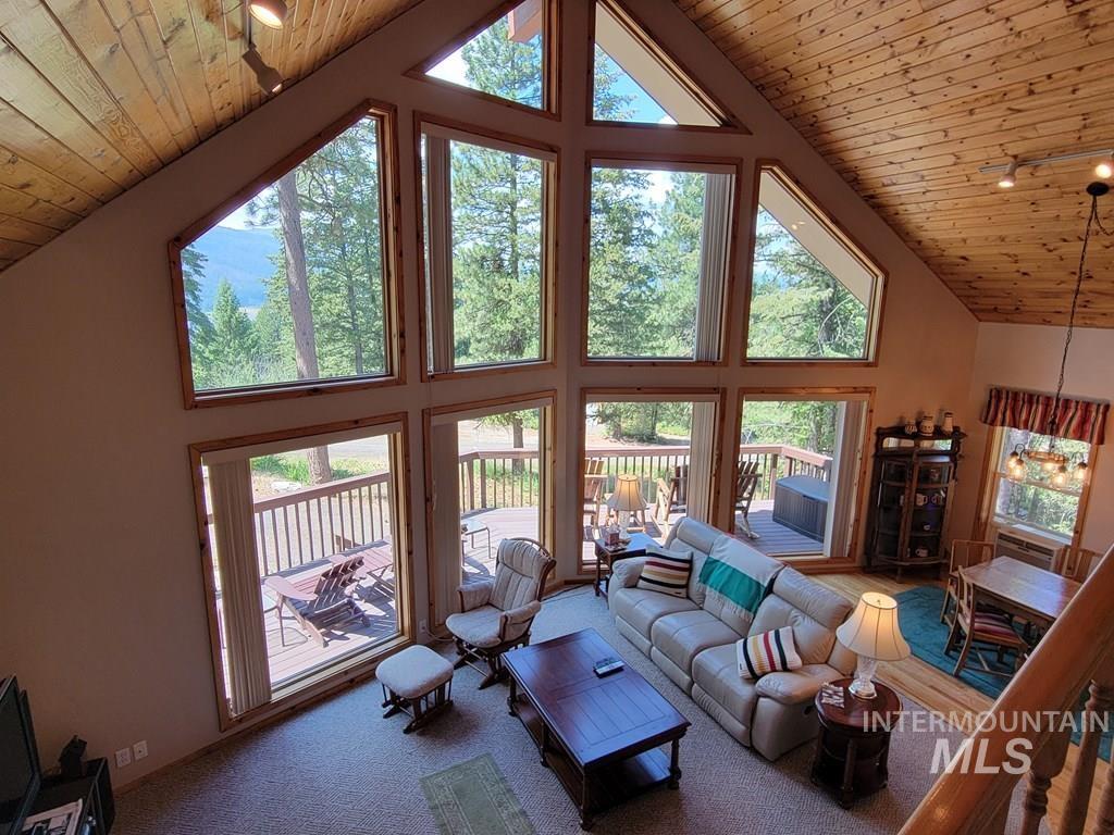 Living room with high vaulted ceiling, wood ceiling, and carpet floors