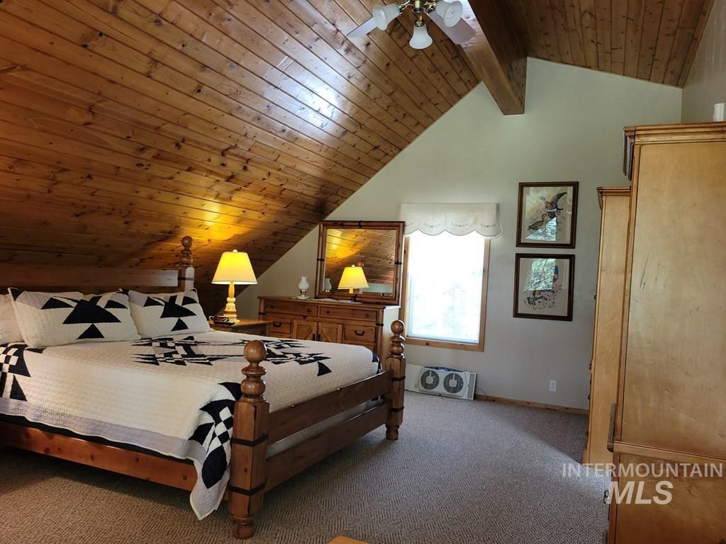 Carpeted bedroom with wooden ceiling and a ceiling fan