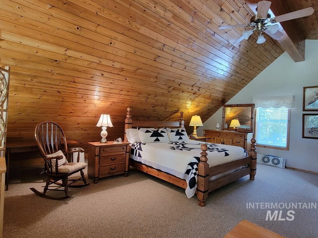 Bedroom with wood ceiling, carpet, and ceiling fan