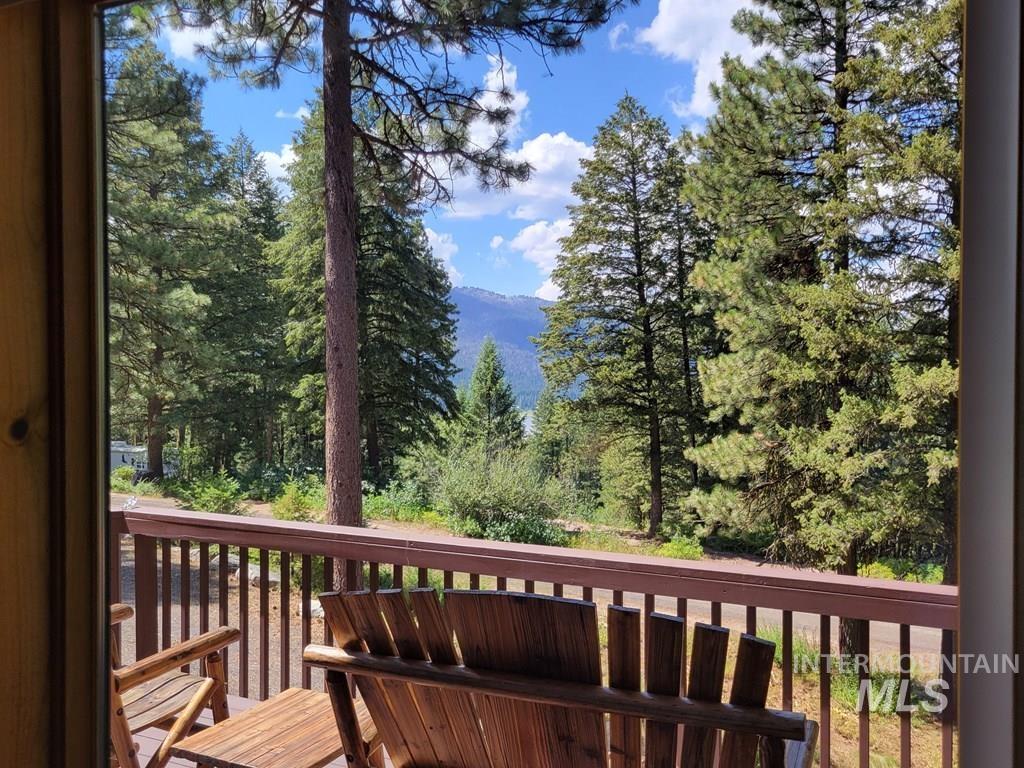 Wooden terrace featuring view of scattered trees and a mountain view