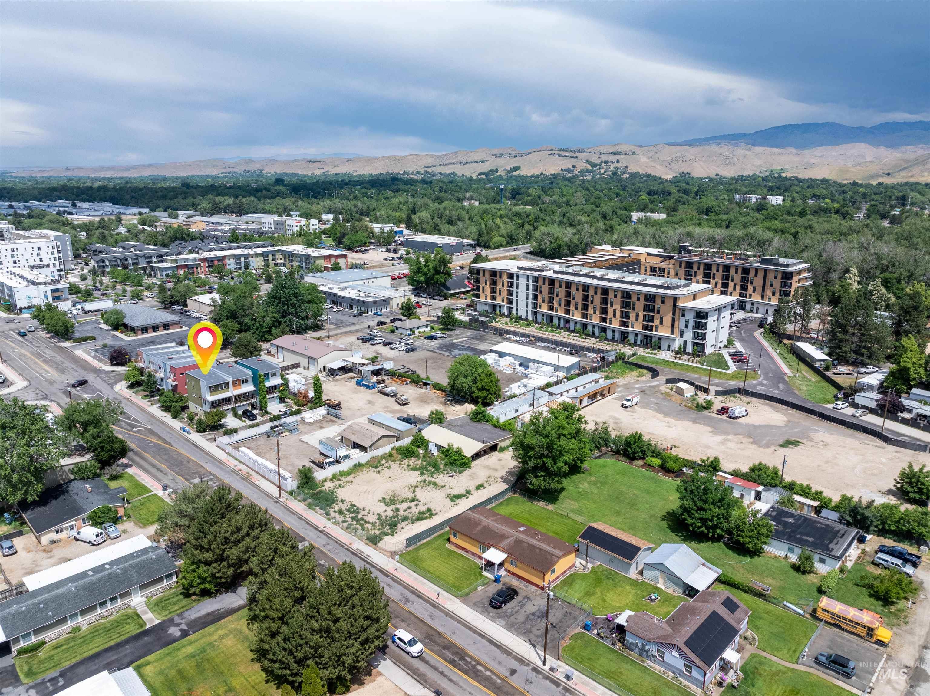 Urban landscape featuring multiple multi-story residential buildings, paved roadways, and green spaces