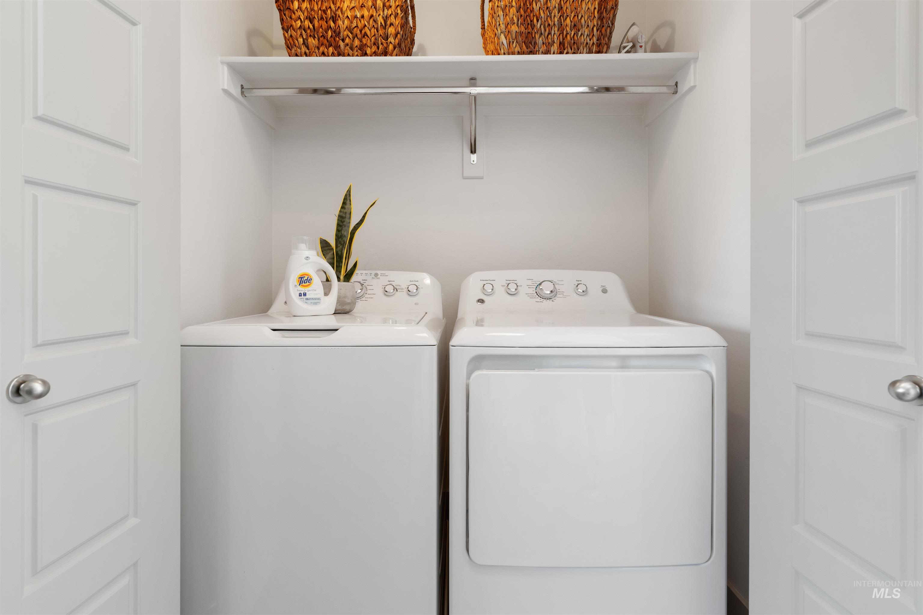 Dedicated laundry alcove featuring a top-load washing machine and front-load dryer