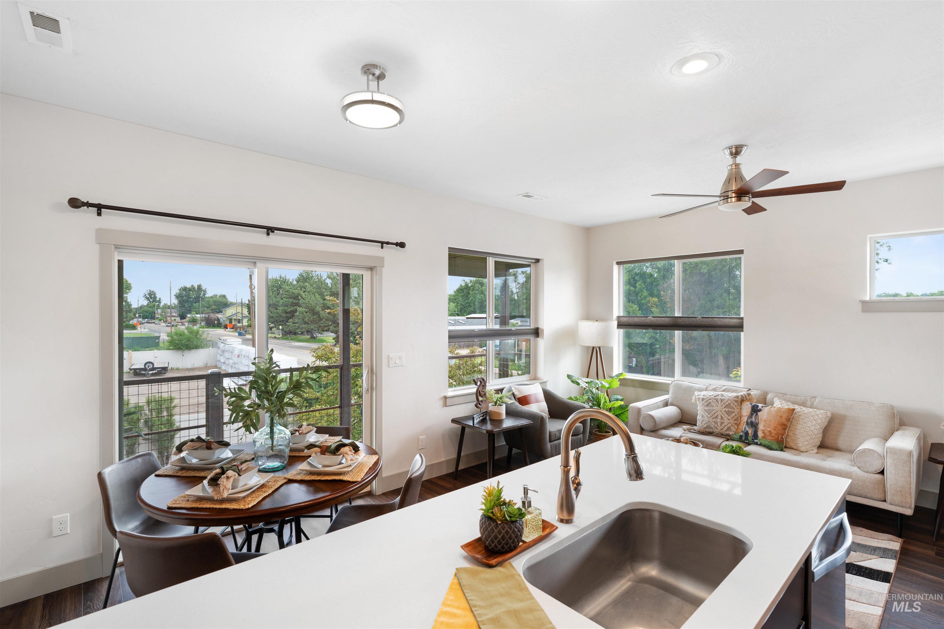 Open-concept living space with a kitchen island featuring an undermount sink and gooseneck faucet