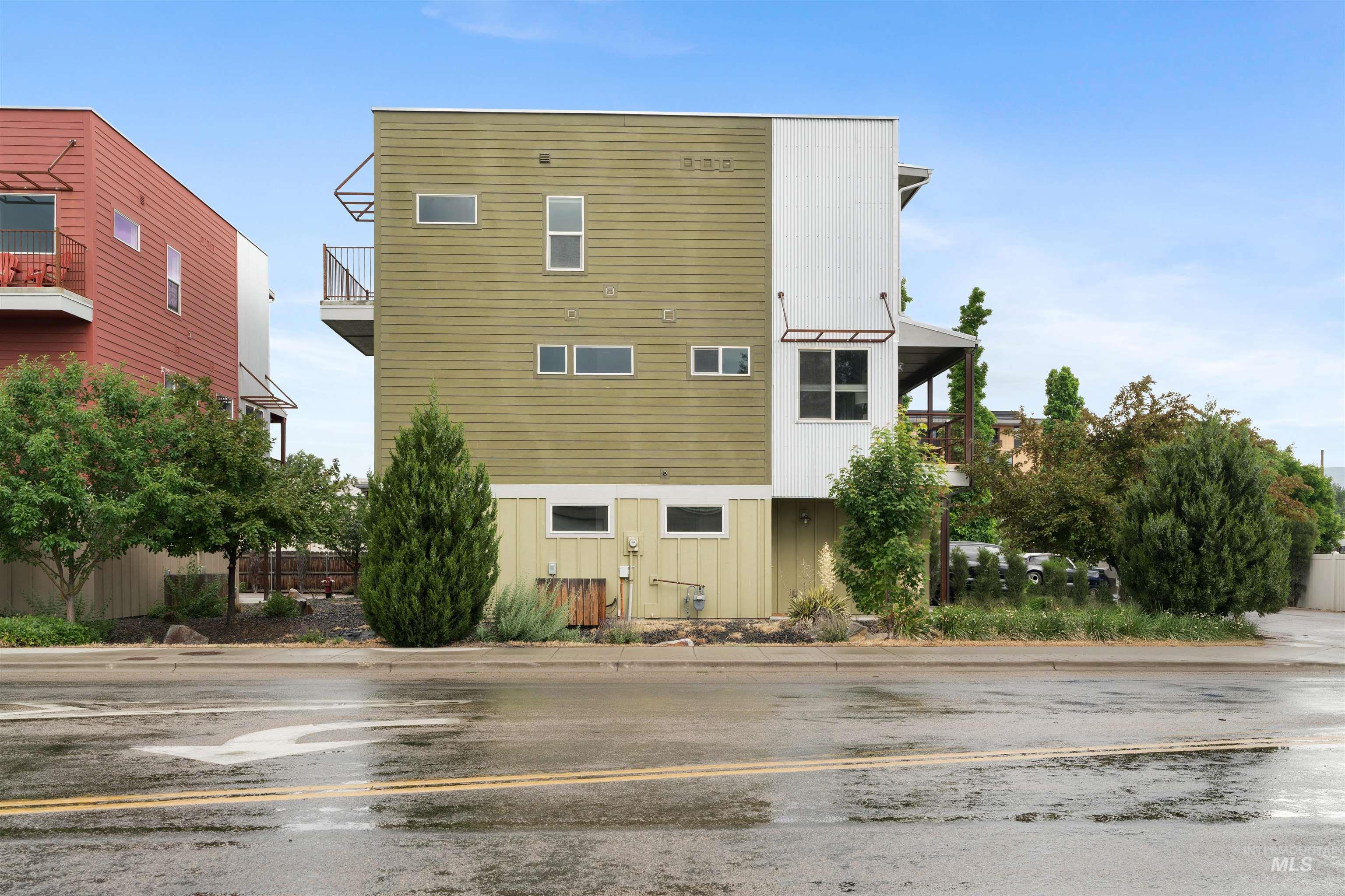 Contemporary multi-level residence featuring a distinctive multi-color facade with olive green and white siding