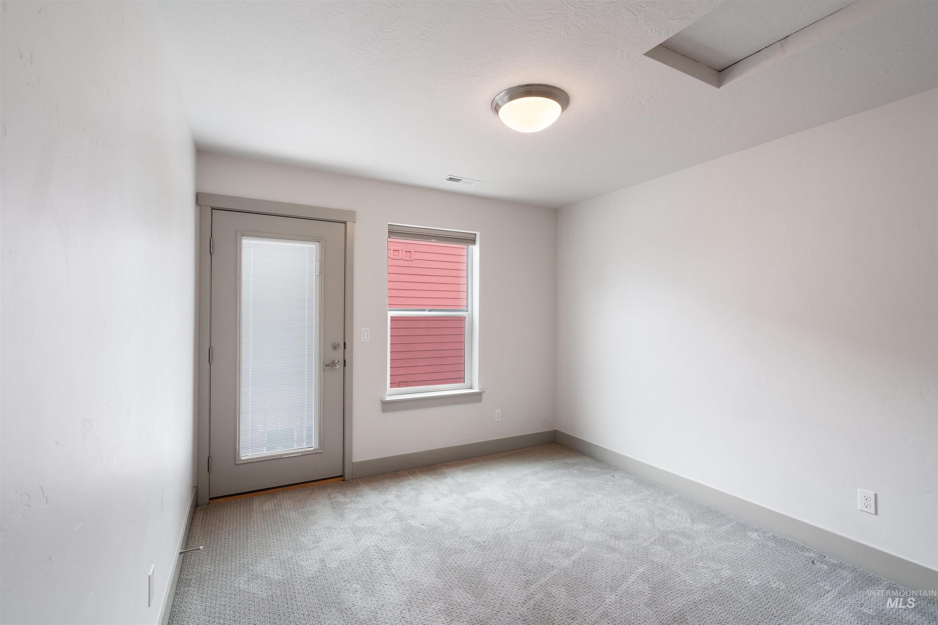 Carpeted room with a frosted glass panel door and a window