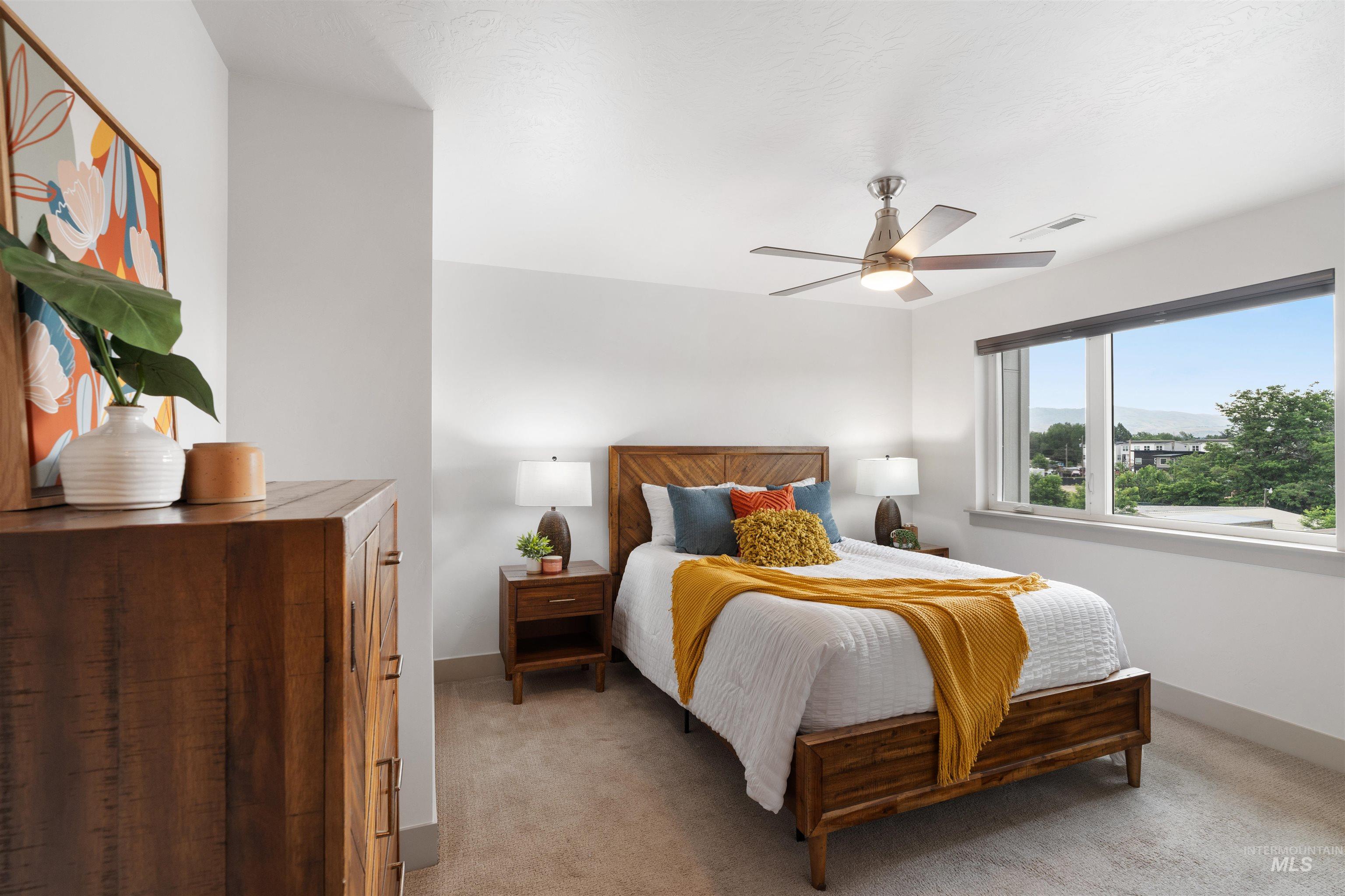 Bedroom featuring a large window, neutral wall paint, and carpet flooring