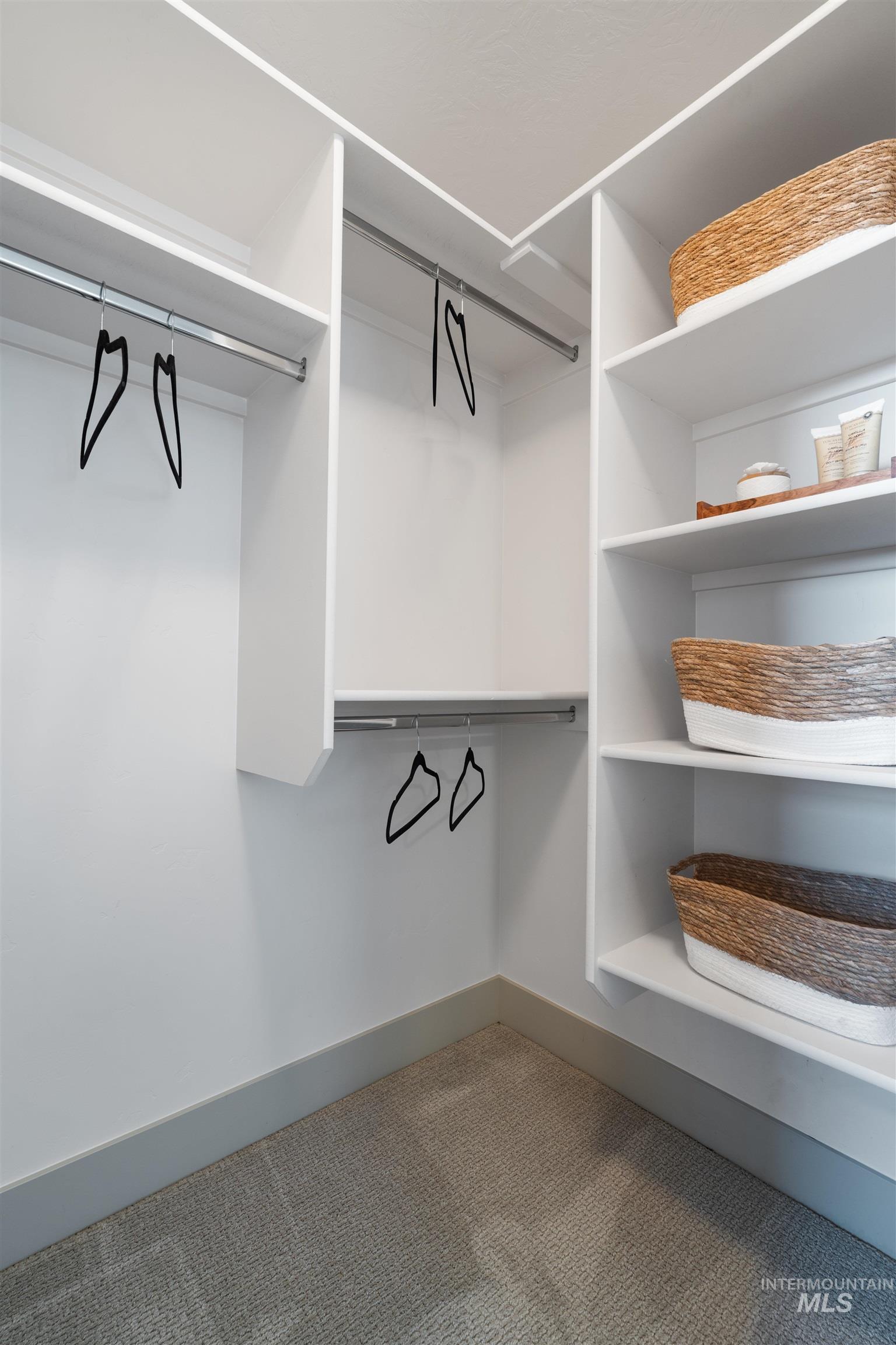 Custom-built closet system featuring white shelving and chrome hanging rods