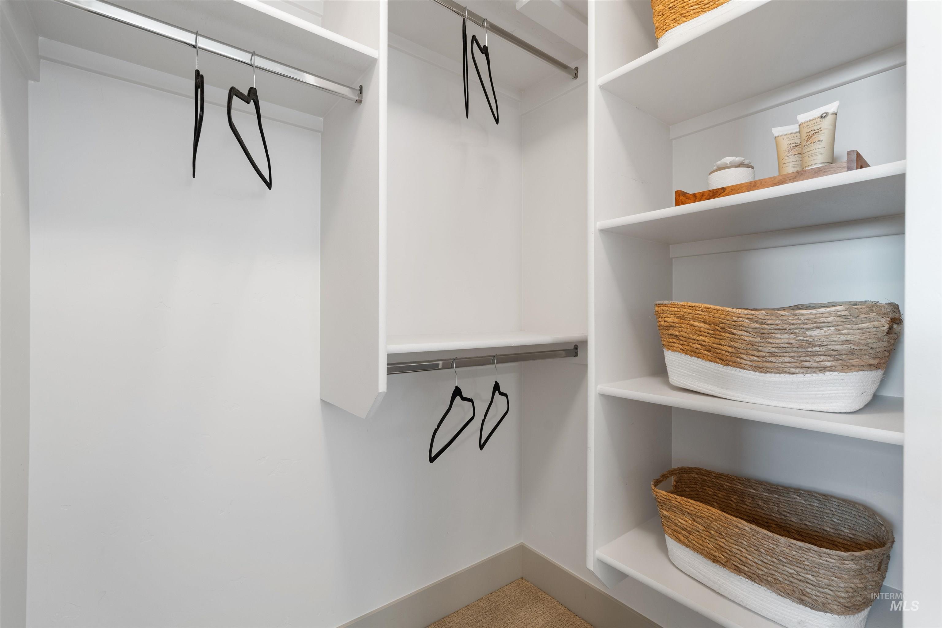 Custom closet system featuring white shelving and chrome hanging rods