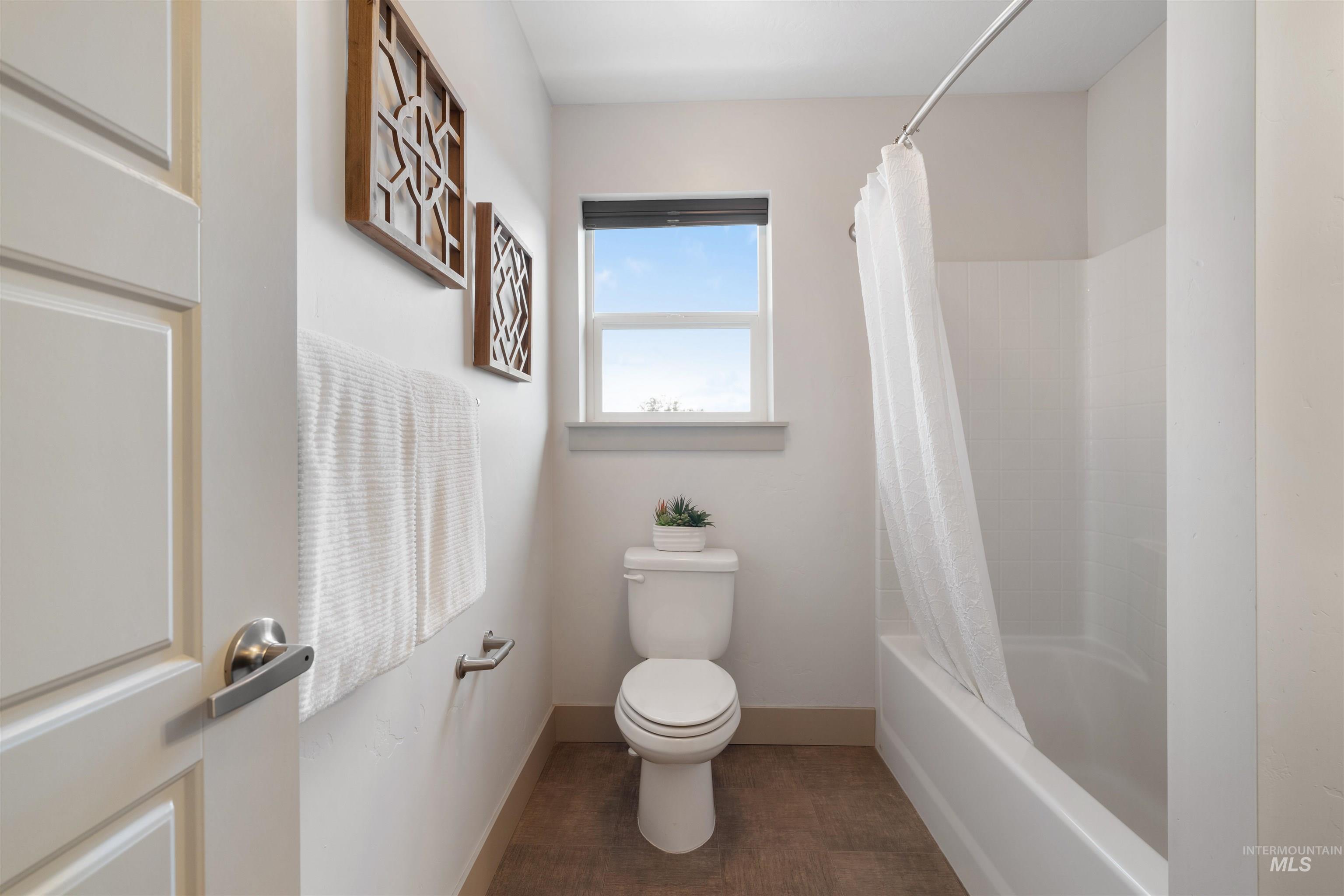 White shower-tub combination featuring a curved shower rod