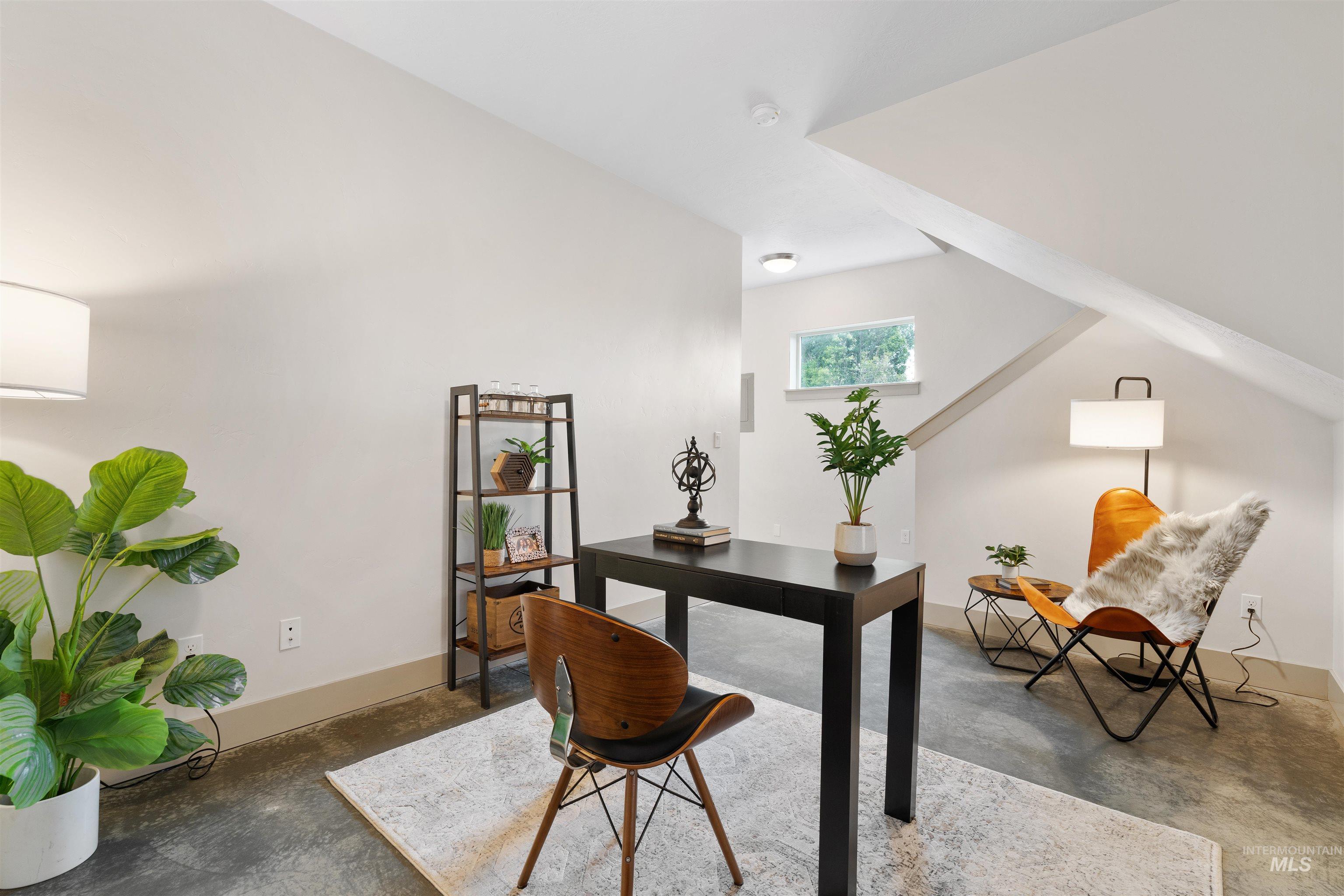 Finished attic space with sloped ceilings and exposed concrete flooring