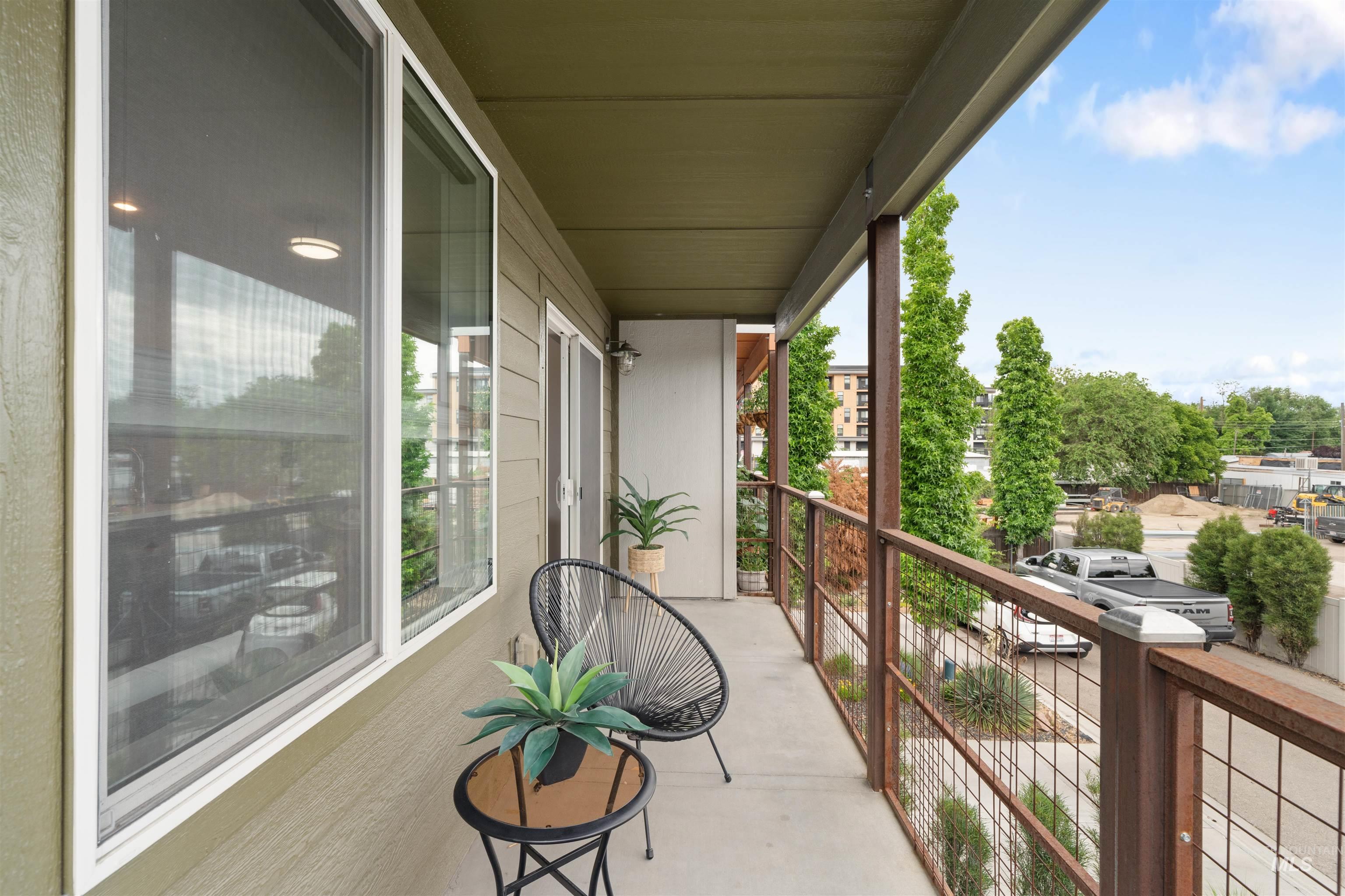Private balcony with concrete flooring, wood-finish siding, and a metal railing