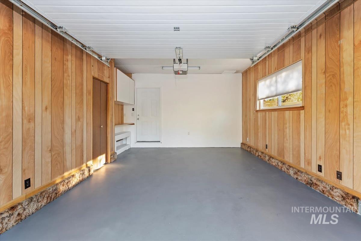 Garage with wooden walls and a garage door opener