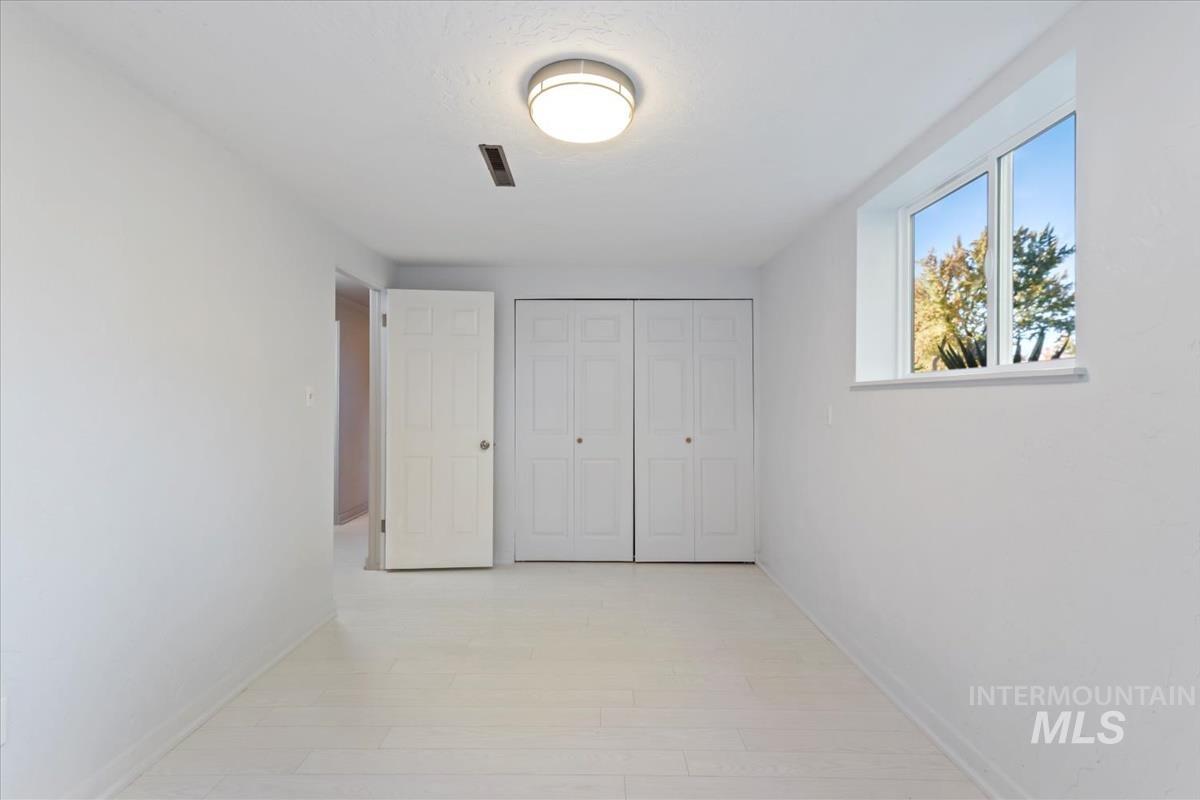 Unfurnished bedroom with a closet and light wood-style flooring