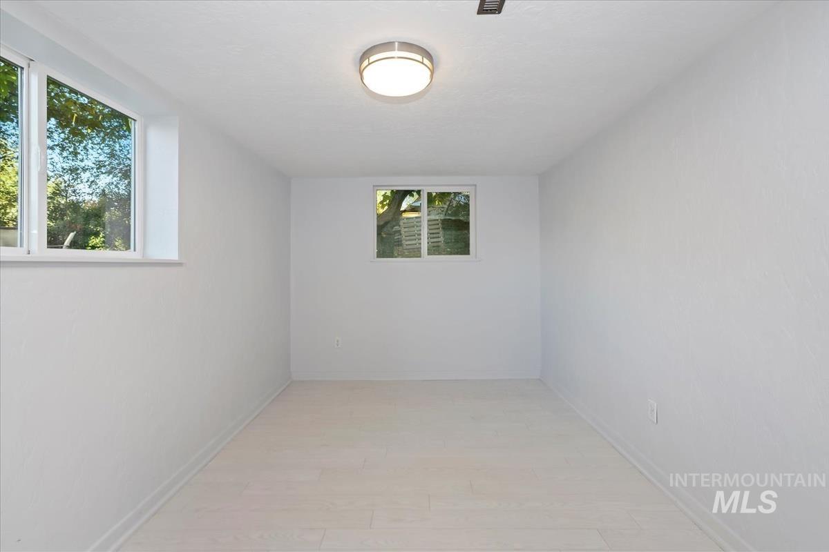 Empty room featuring baseboards and light wood finished floors