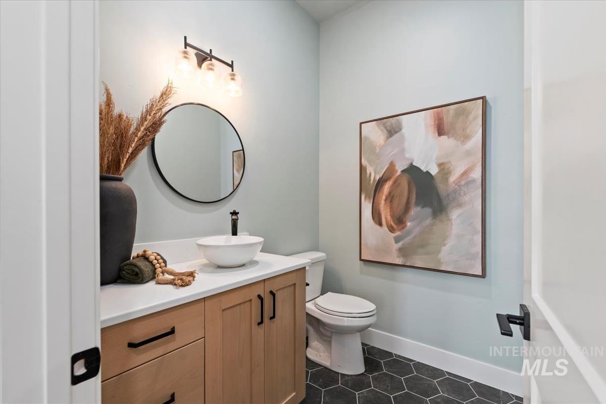 Bathroom featuring vanity and dark tile patterned floors