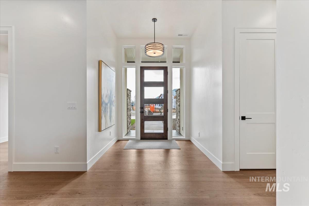 Foyer entrance featuring wood finished floors and a towering ceiling