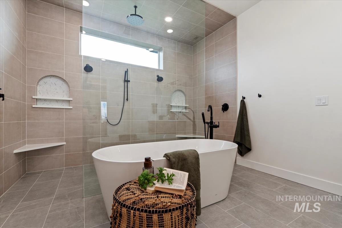 Full bath with a freestanding tub, tile patterned flooring, and walk in shower