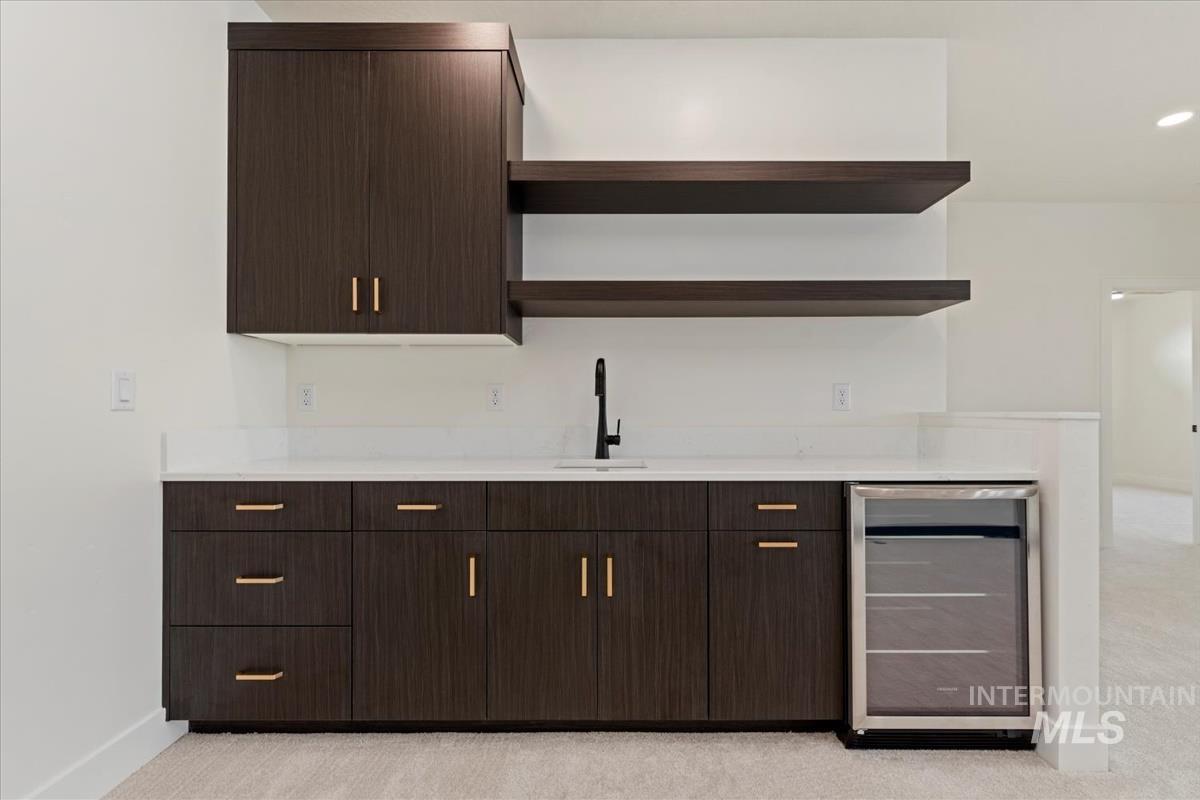 Bar with open shelves, dark brown cabinetry, beverage cooler, and modern cabinets
