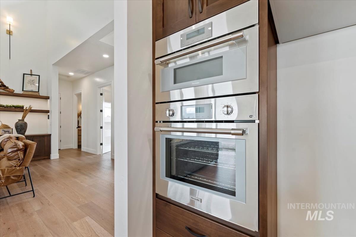 Kitchen featuring double oven, light wood finished floors, and recessed lighting