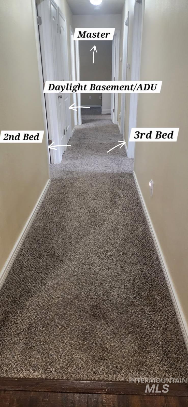 Corridor featuring baseboards and carpet