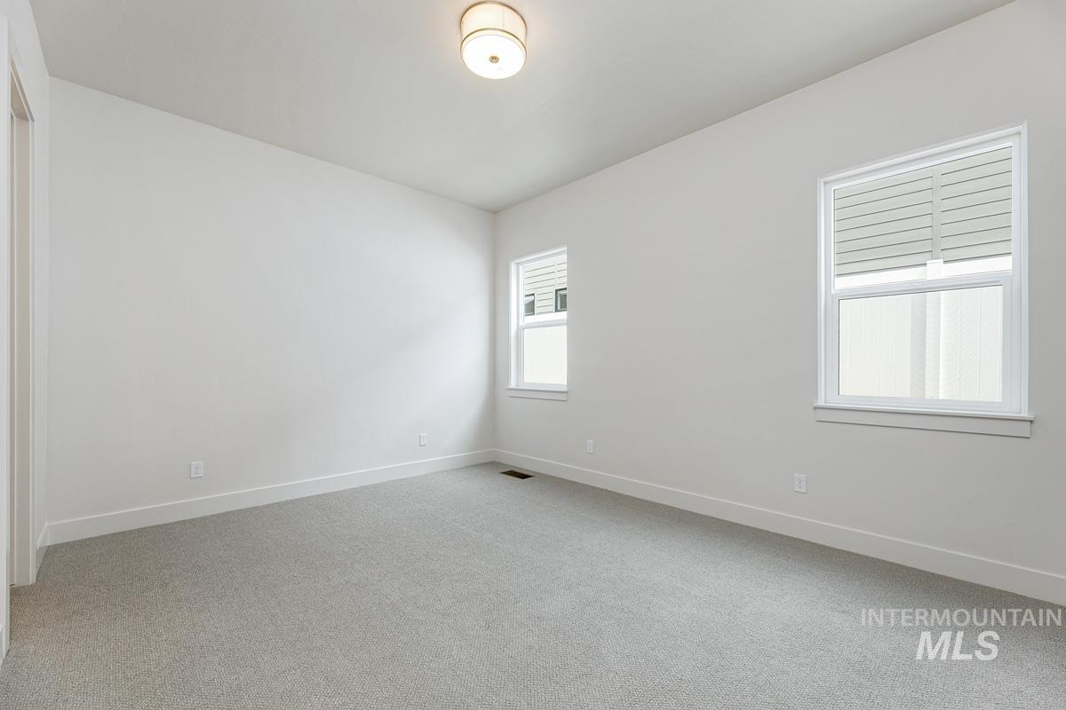 Spare room featuring light colored carpet and baseboards