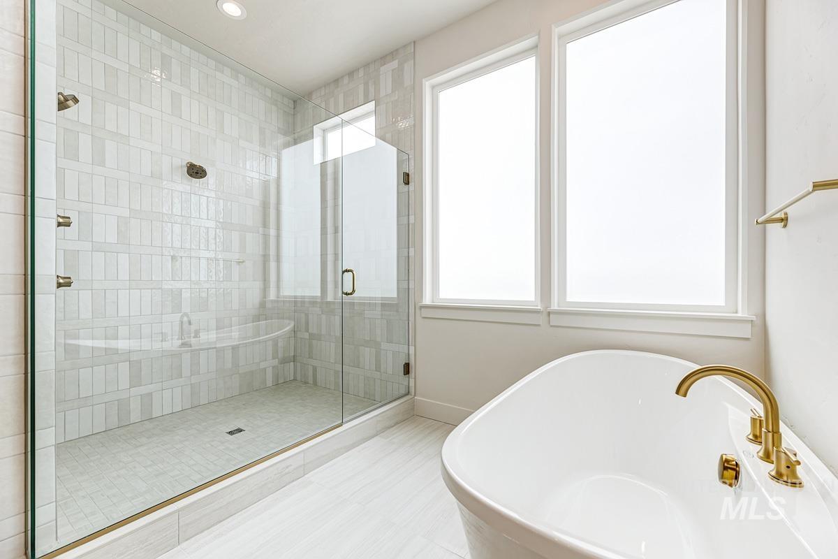 Full bath featuring a freestanding bath, a stall shower, and recessed lighting