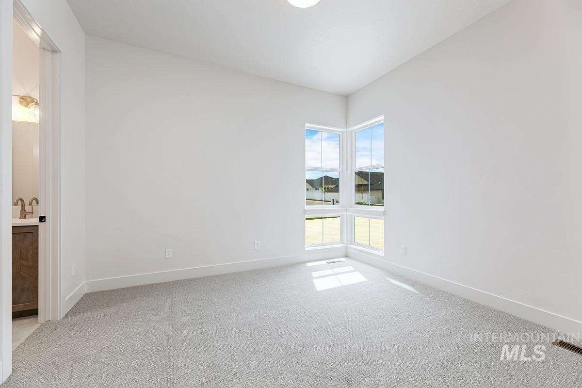Empty room with light carpet and baseboards