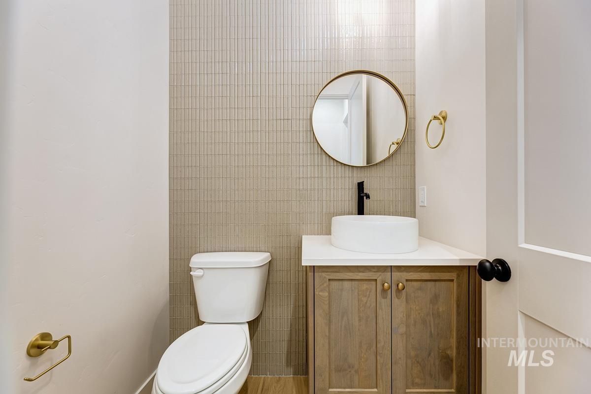Half bathroom with vanity and tile walls