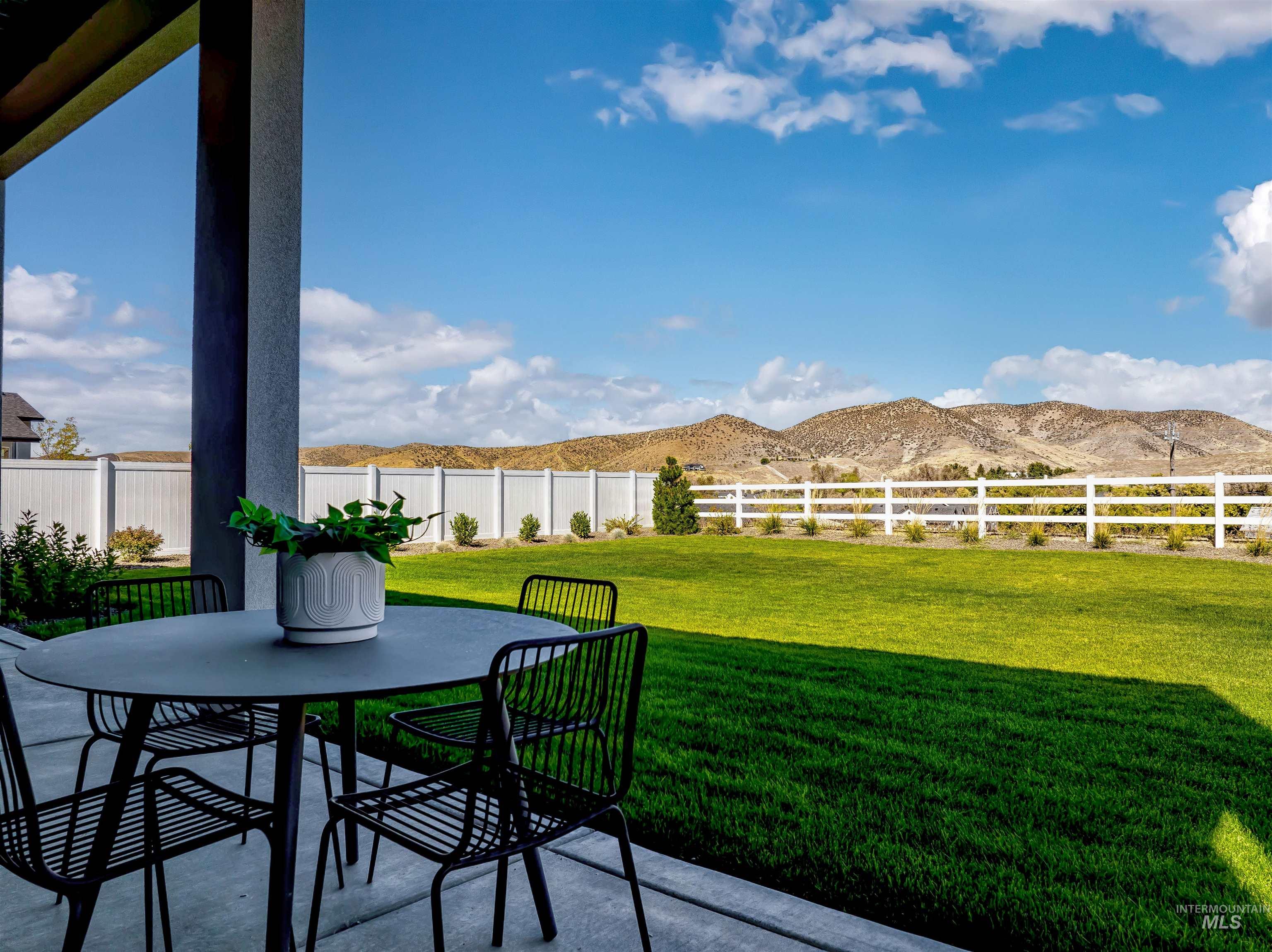 Fenced backyard with a patio area, outdoor dining area, and a mountain view
