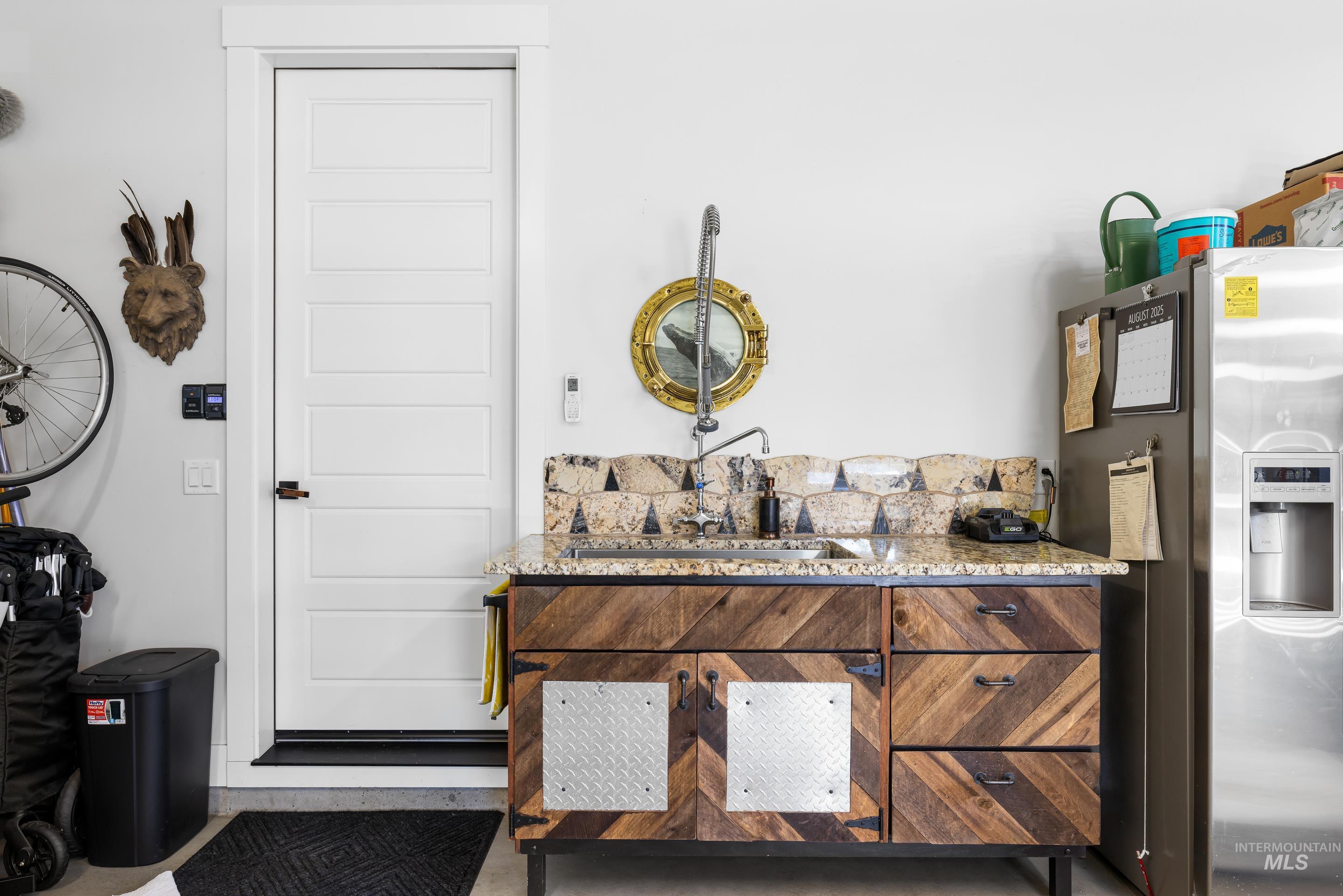 Bar with stainless steel refrigerator with ice dispenser and light stone countertops